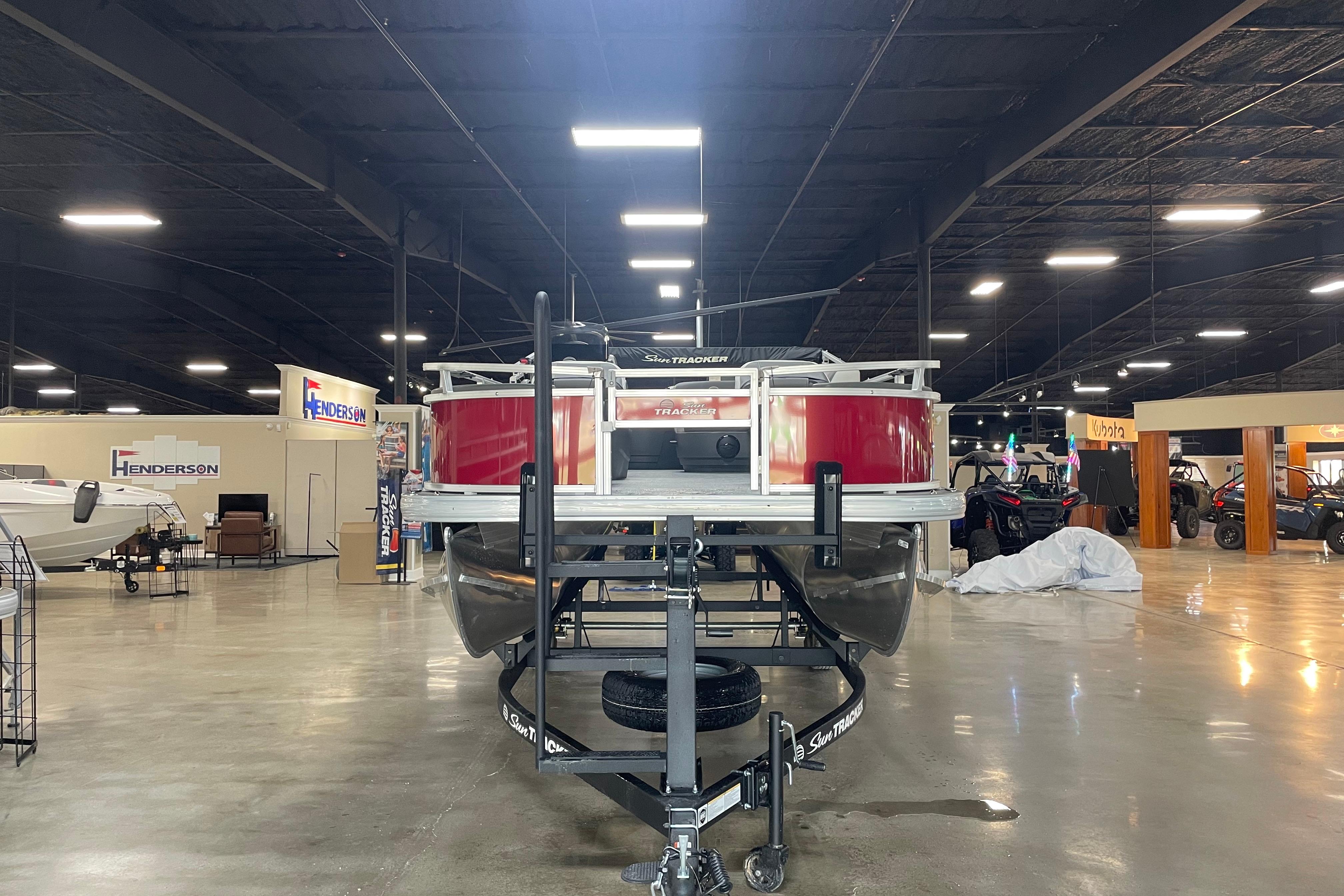 2026 Sun Tracker Bass Buggy 18 DLX pontoon boat displayed indoors at a showroom.