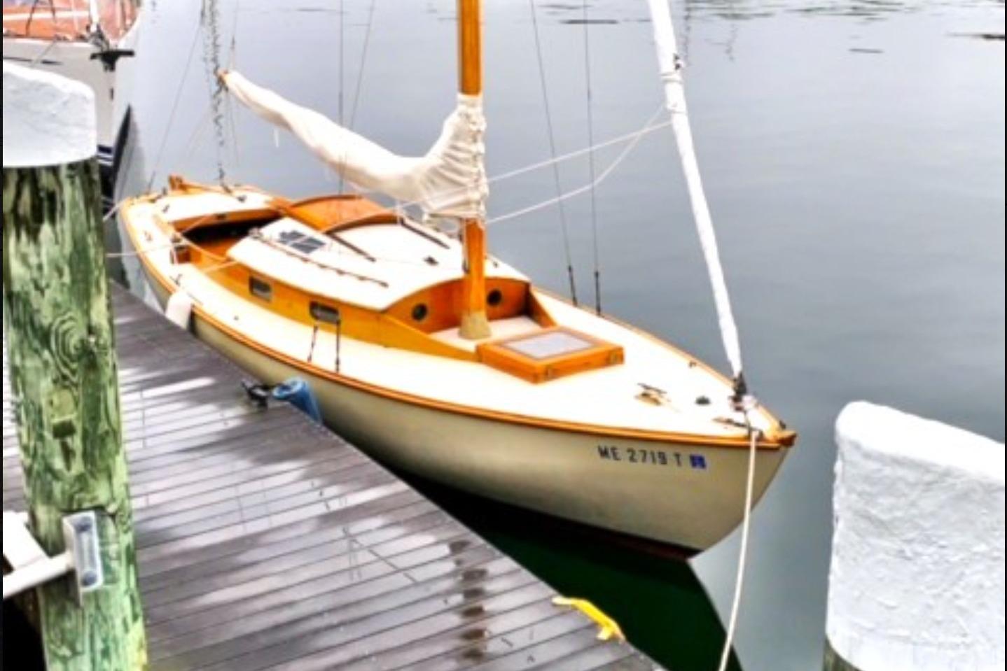 Vintage 1950 Mason Ostkust Sloop docked at a calm marina.