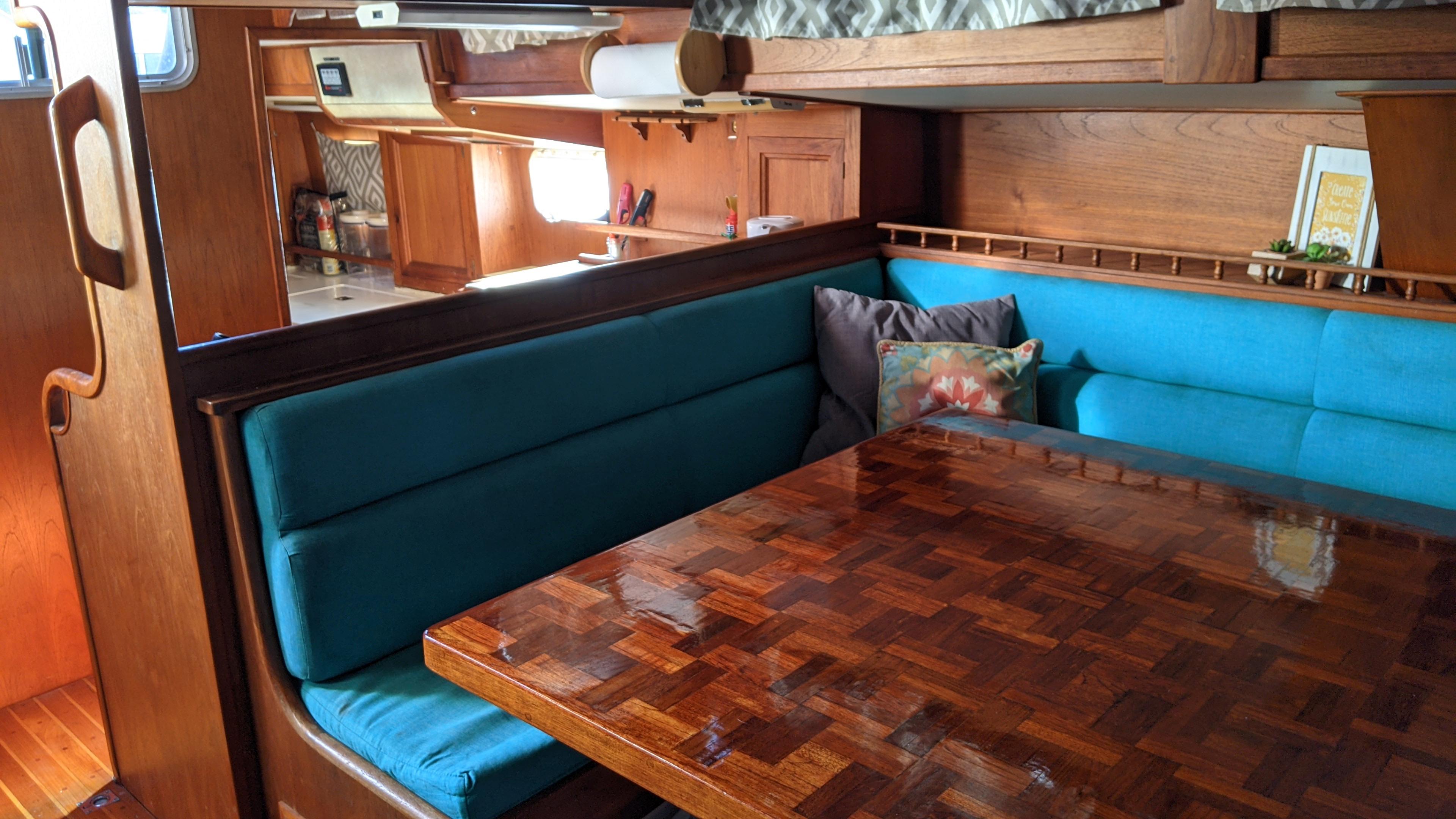 Interior of 1979 Maple Leaf 54ft Center Cockpit Cutter with wooden table and blue seating.