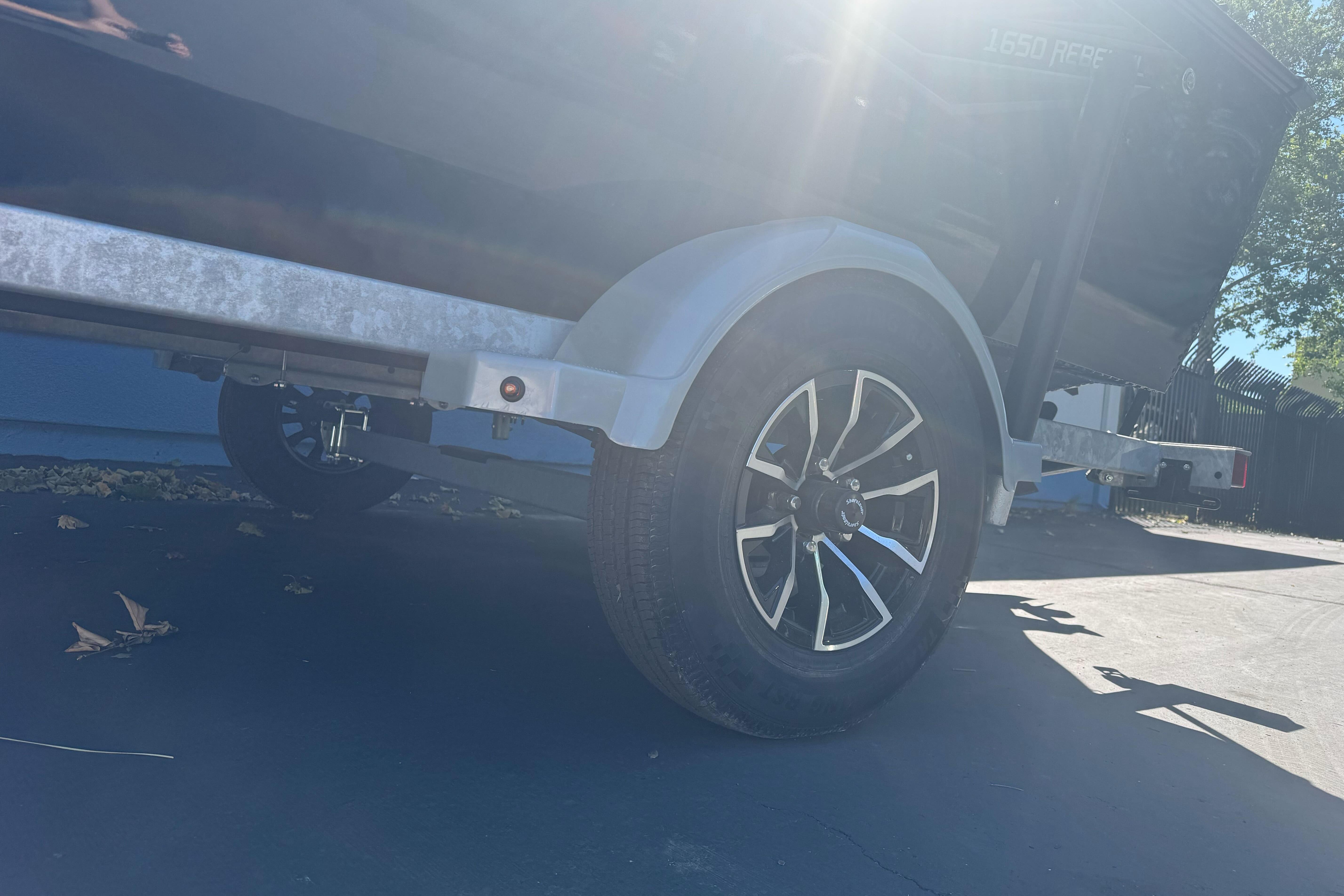 2026 Lund 1650 Rebel XL SS trailer wheel in sunlight.