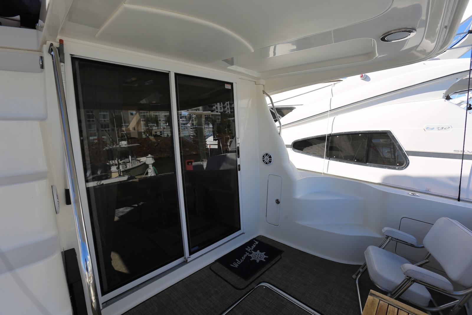 2004 Sea Ray 420 Sedan Bridge yacht deck with sliding glass doors and seating area.