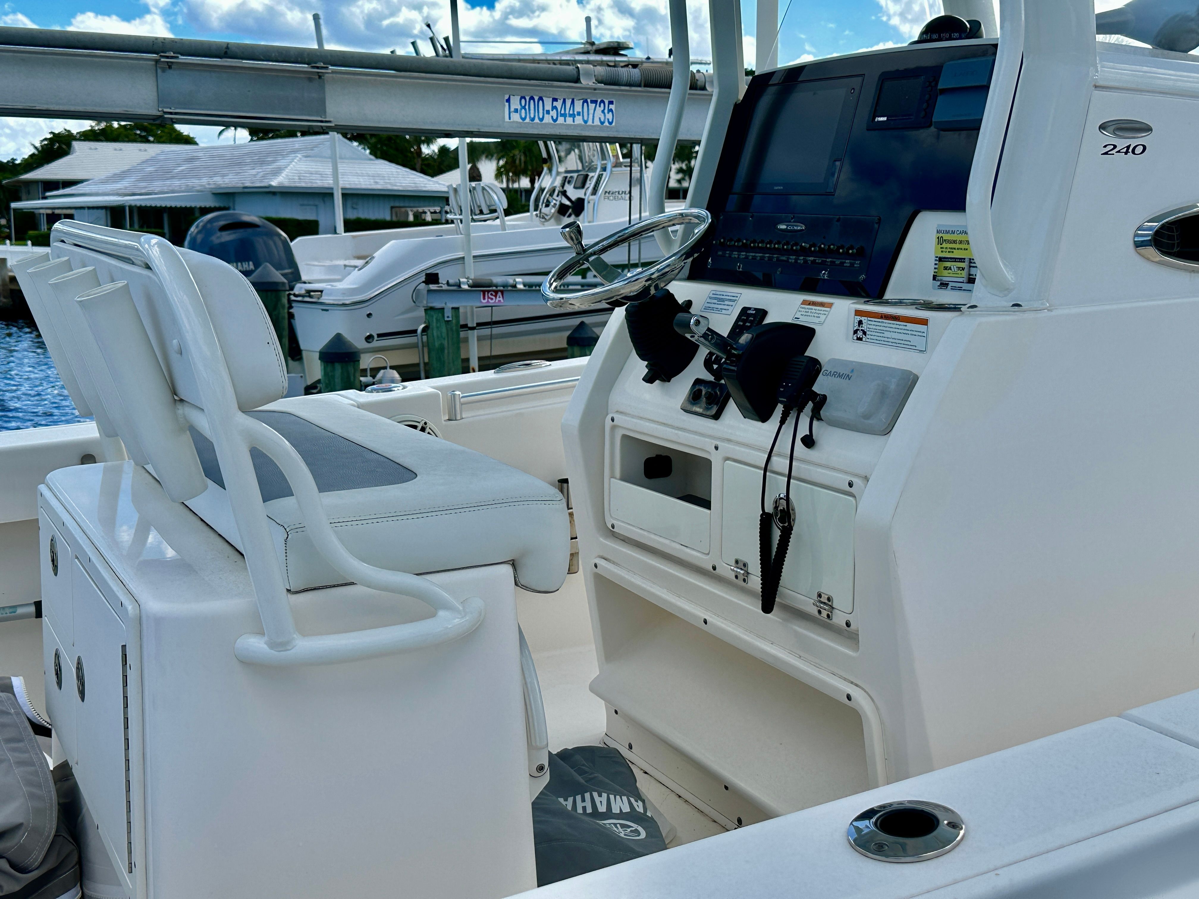 The image shows the cockpit of a 2022 Cobia 240 Center Console boat.