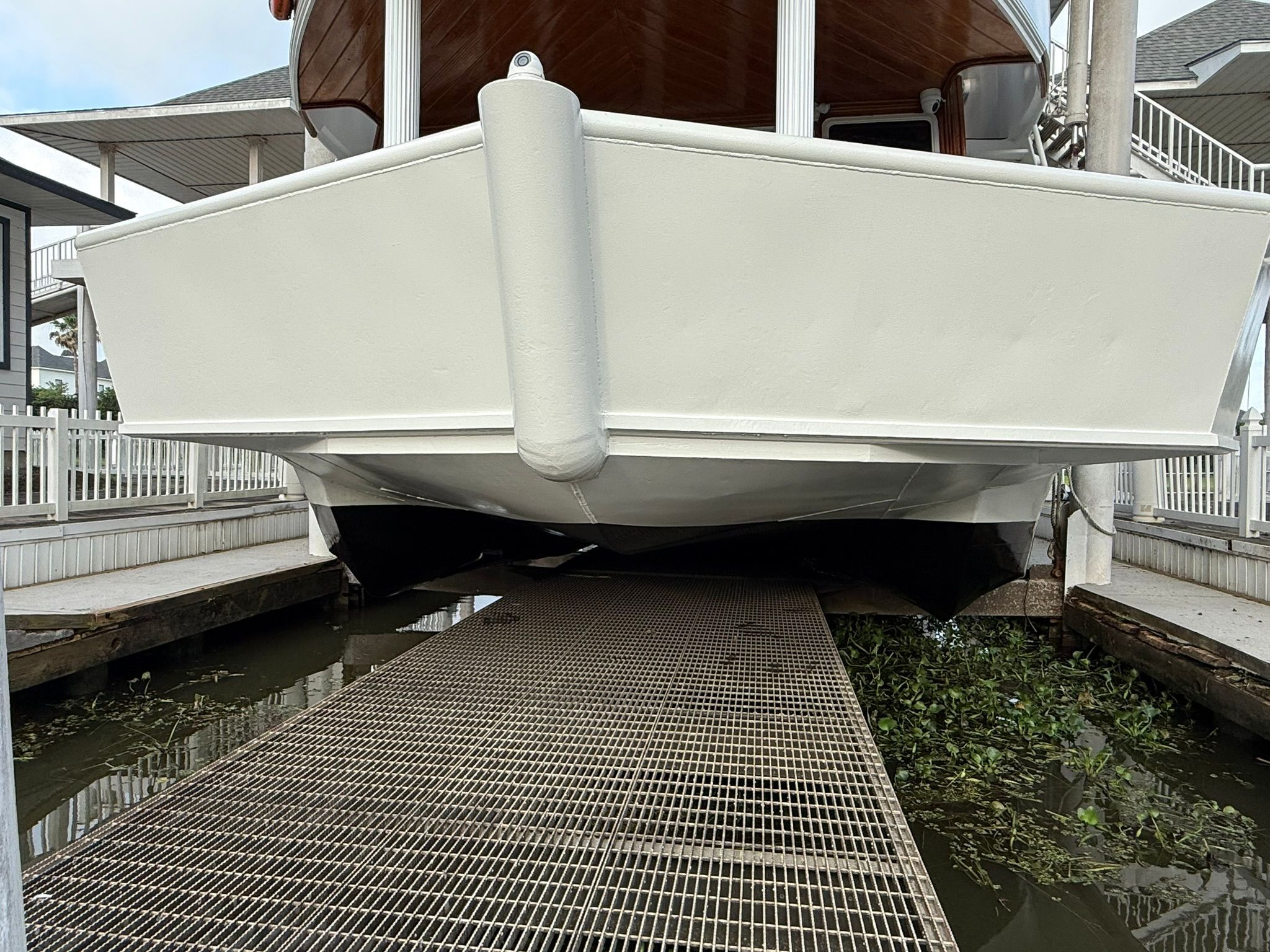A boat is in a dry dock, surrounded by water and vegetation.