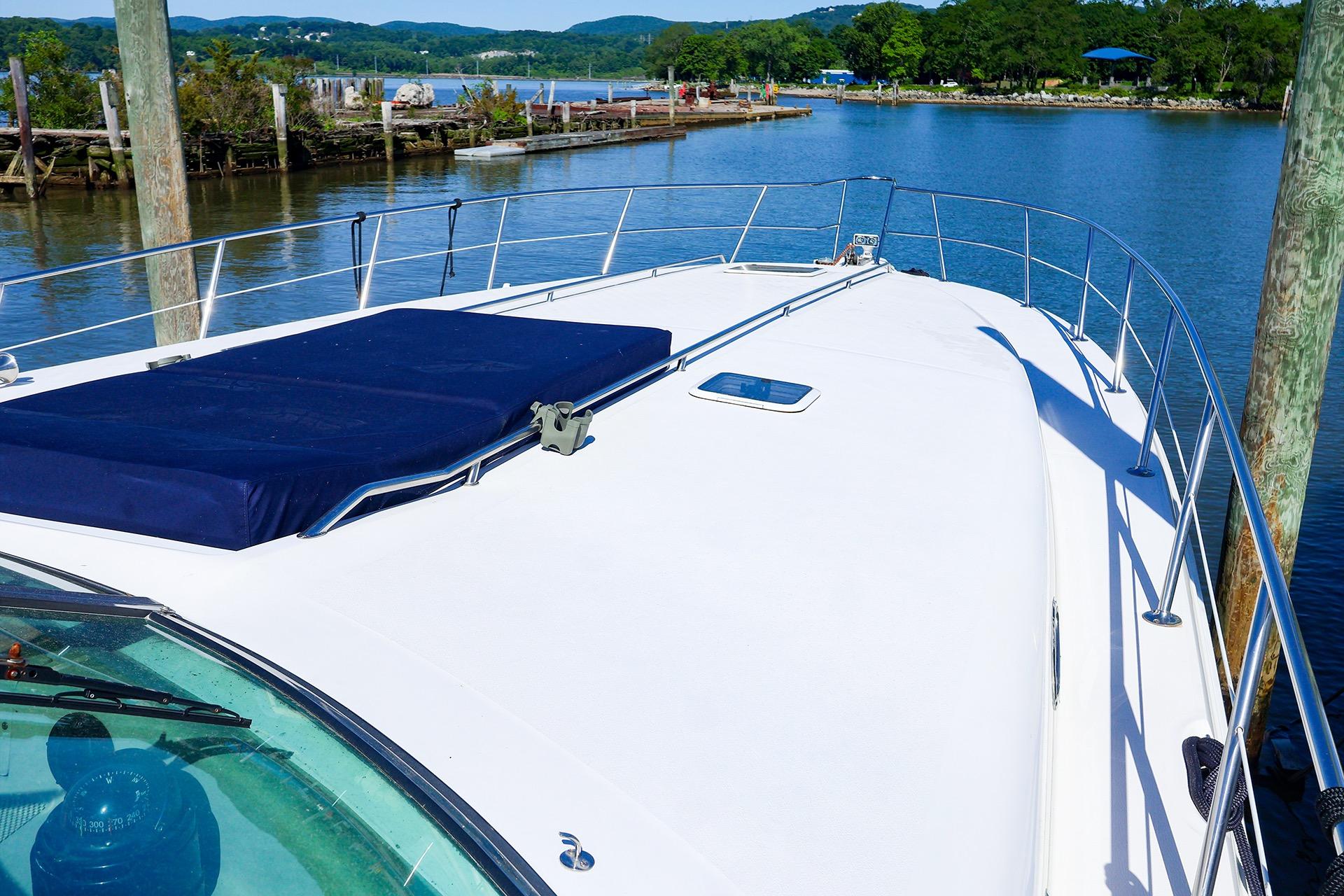 1998 Sea Ray 500 Sundancer yacht docked by scenic waterfront.