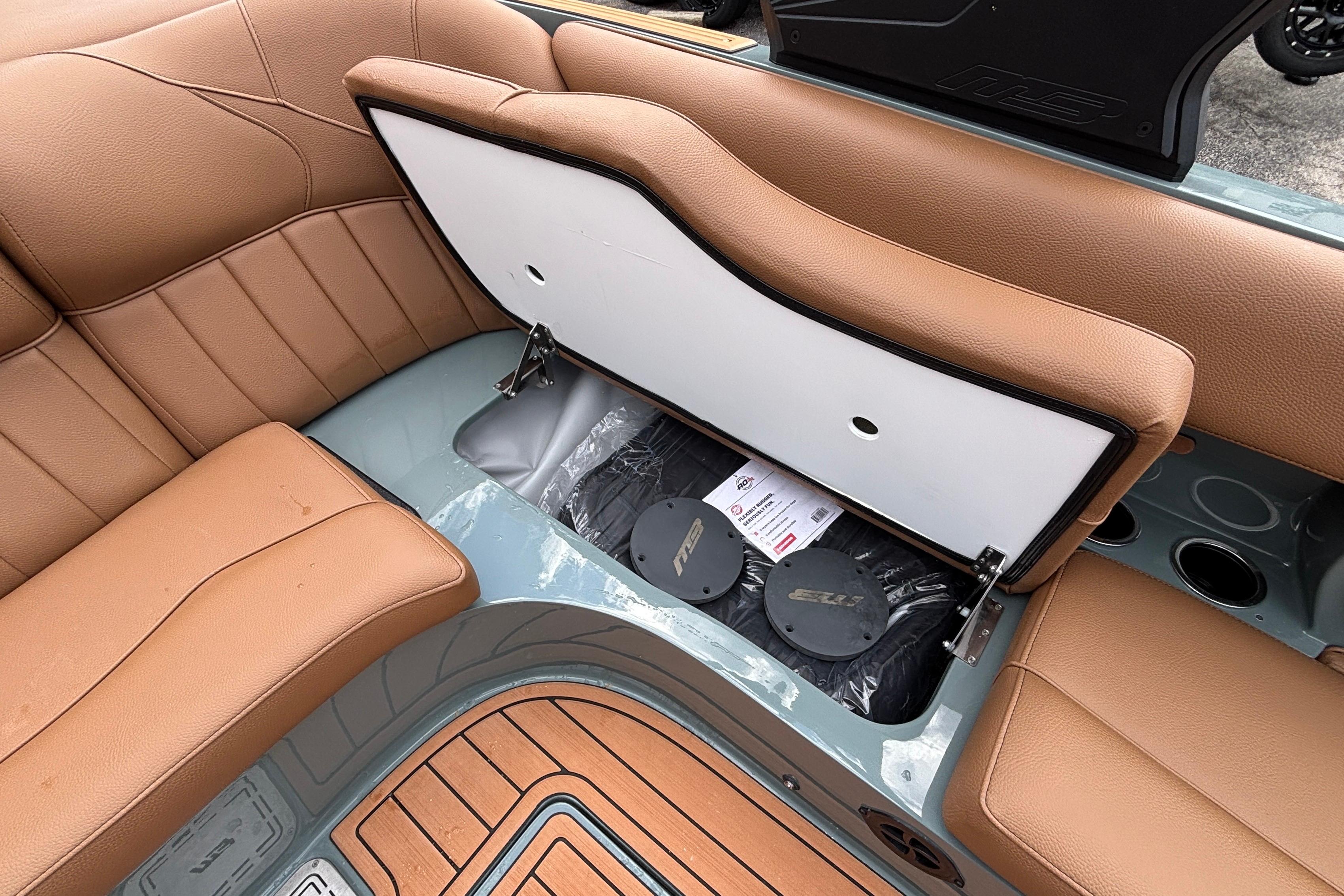 2026 MB B52 23 Classic boat interior with tan seating and open storage compartment.