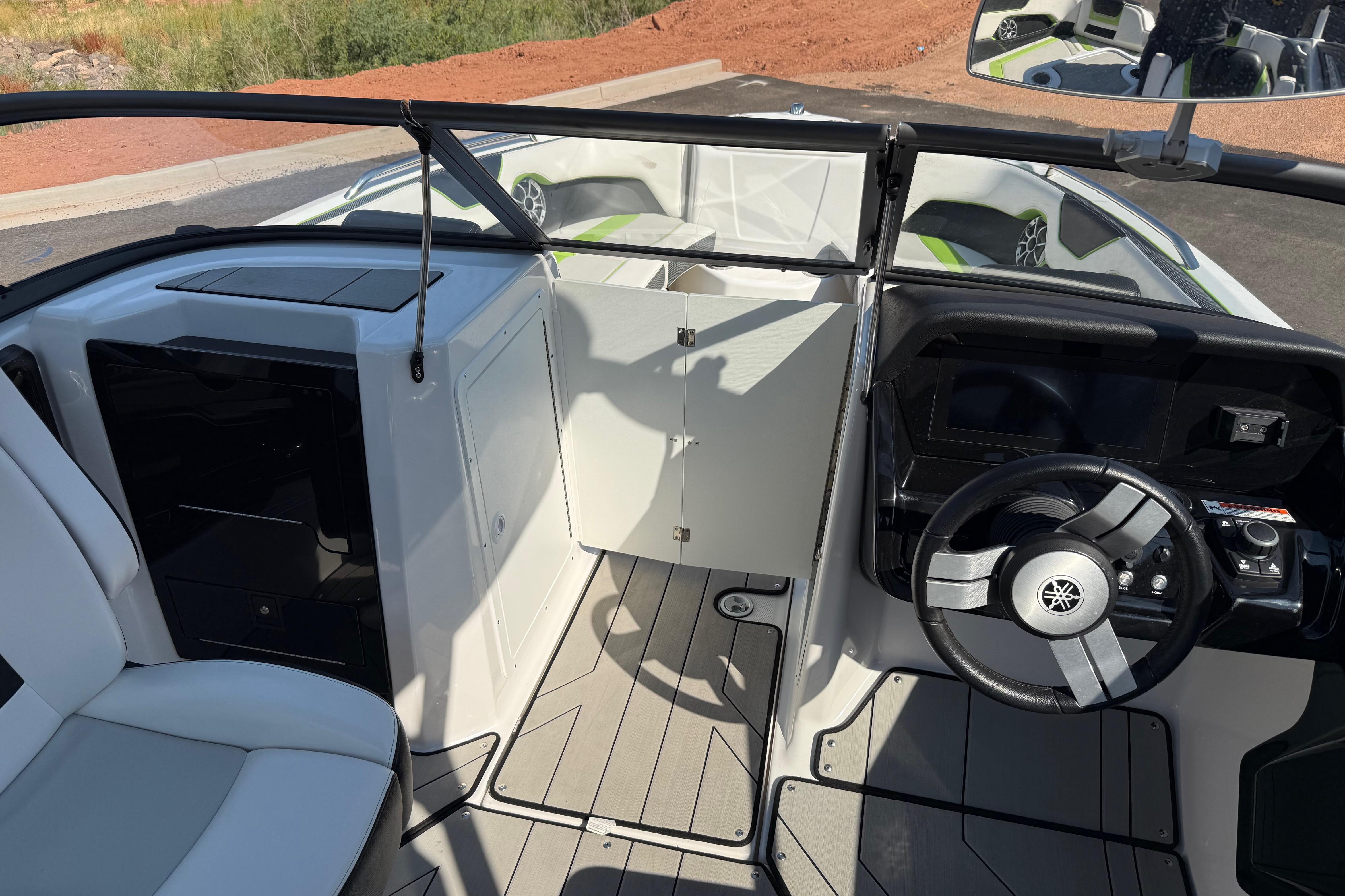 2022 Yamaha Boats 212XE interior with steering wheel and seating area.