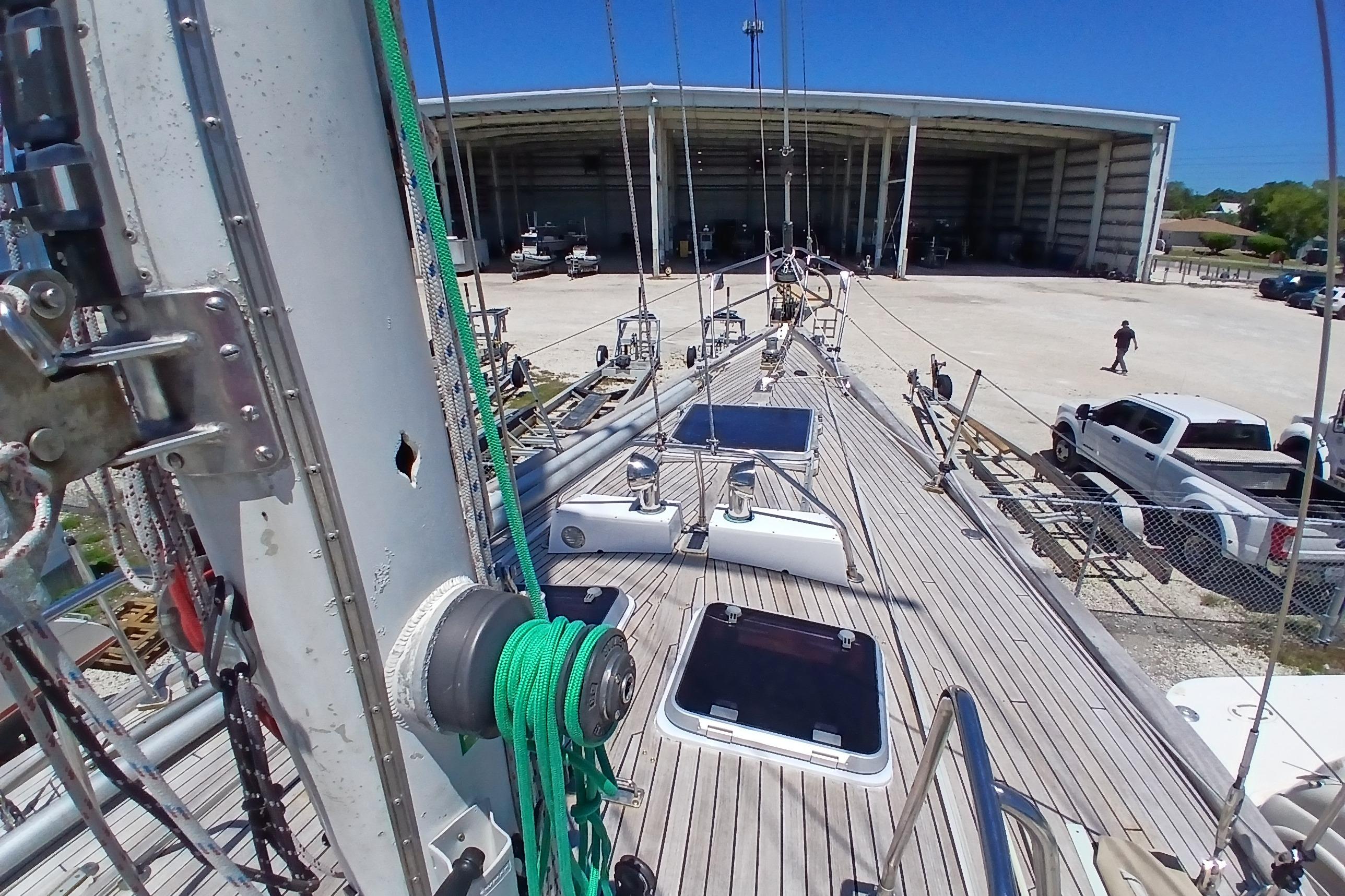 Deck view of 1981 Kaufman Skye 51 sailboat at a marina with trucks nearby.