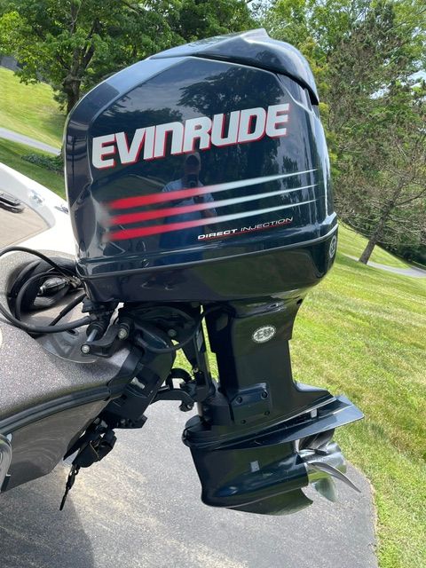 Outboard motor of a boat with Evinrude logo, on a trailer outdoors.