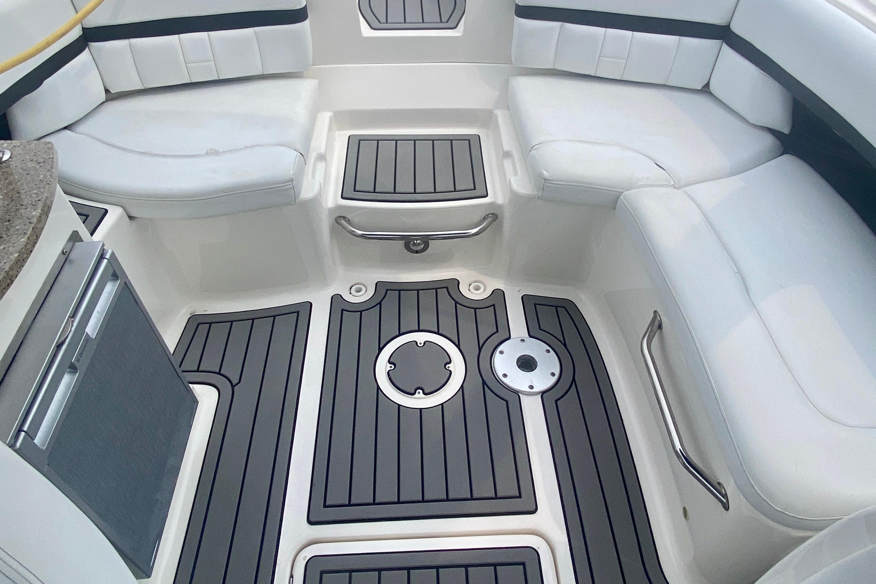 Interior of 2015 Sea Ray 250 SLX boat with cushioned seating and sleek flooring.
