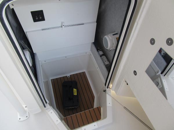 2024 Ranger 2660 Bay boat storage compartment with wooden flooring and equipment.