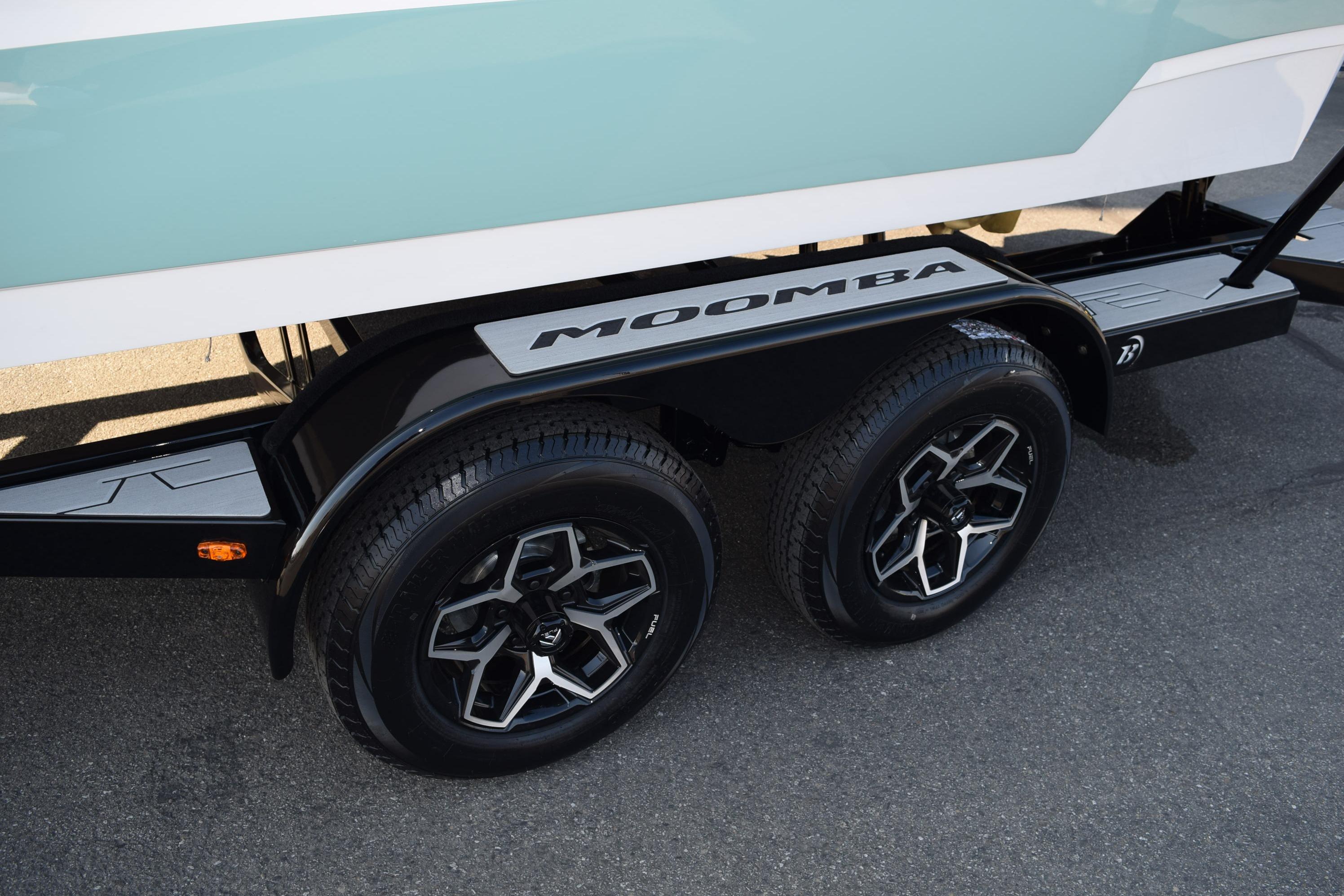 2025 Moomba Mojo trailer with dual wheels and sleek design on pavement.