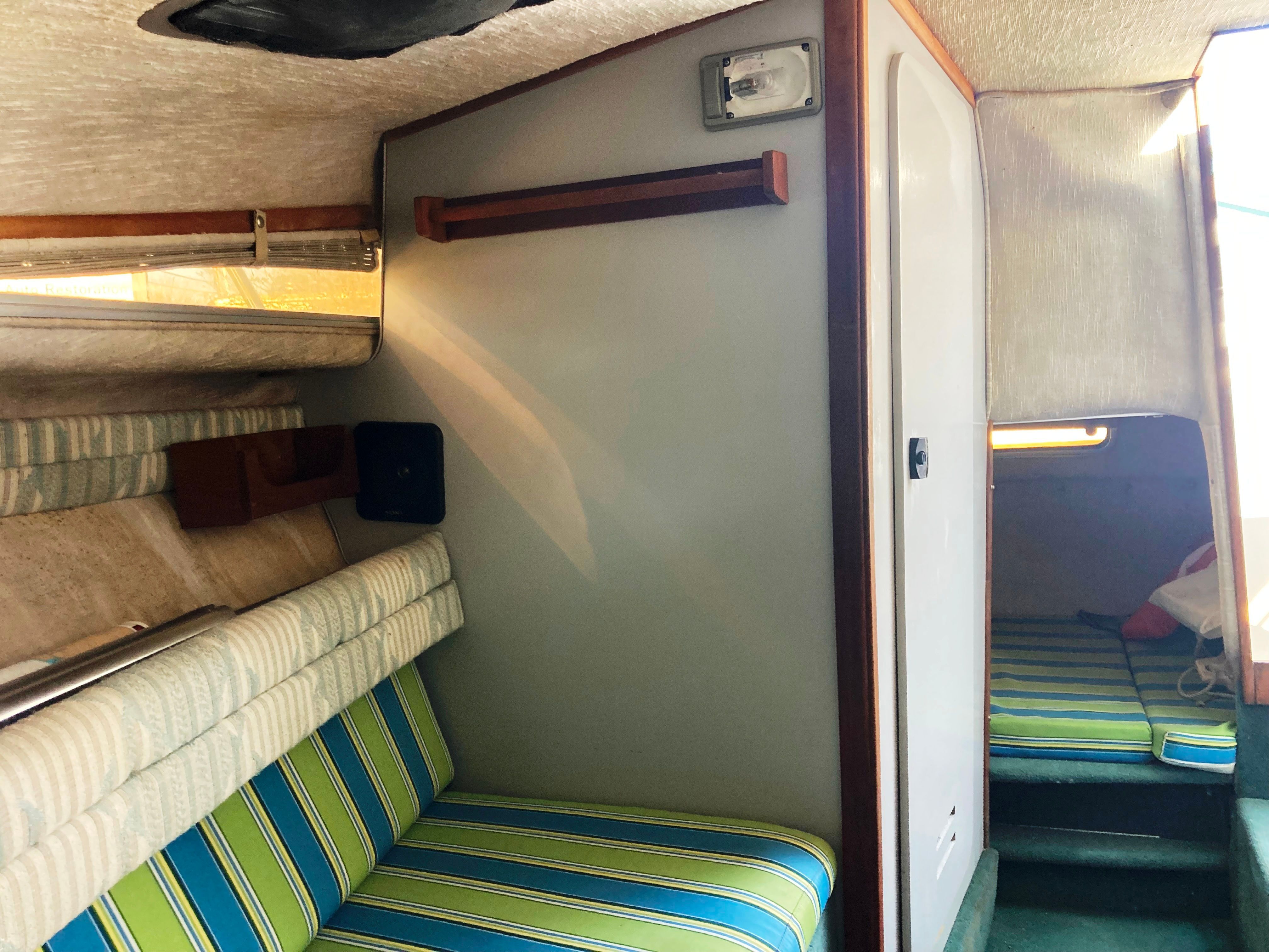 Interior of a 1991 Sea Ray 220 Sundancer with striped upholstery and wood accents.