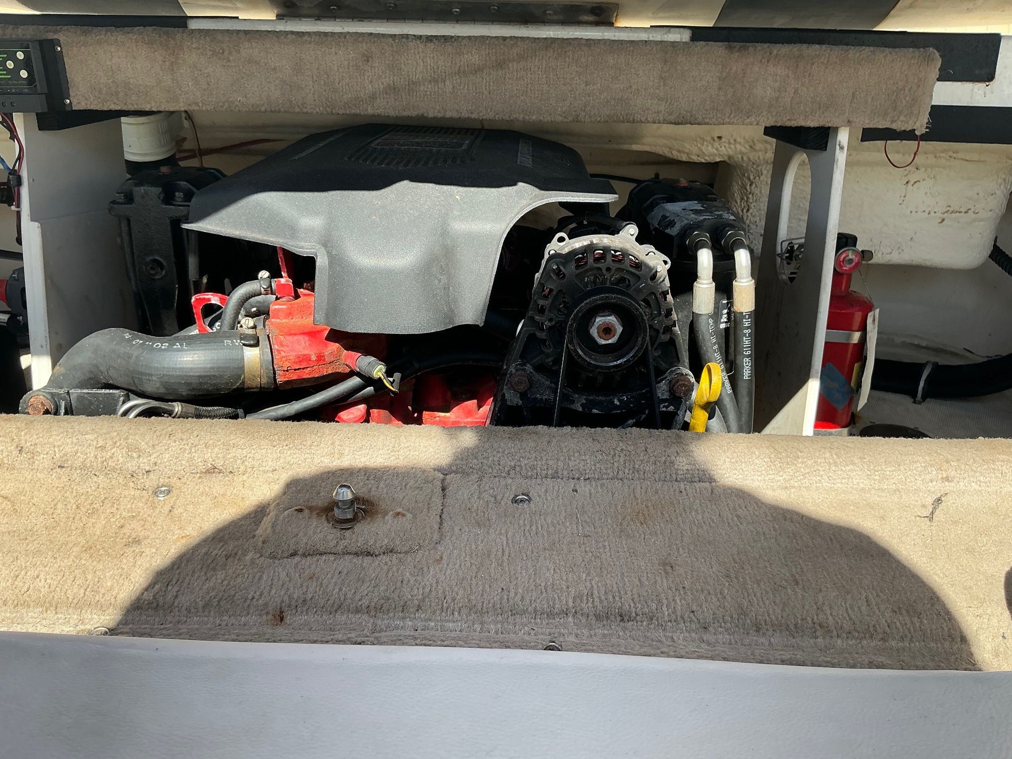 A boat engine compartment with an engine and a fire extinguisher.