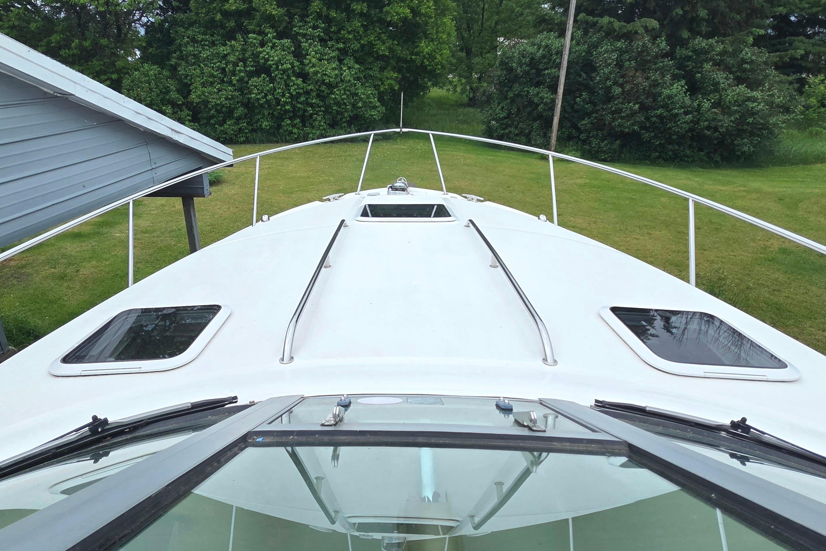 2002 Sea Ray 300 Sundancer boat deck with lush green surroundings.