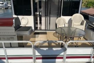 1995 Myacht 40X13 houseboat with outdoor seating and grill on deck.