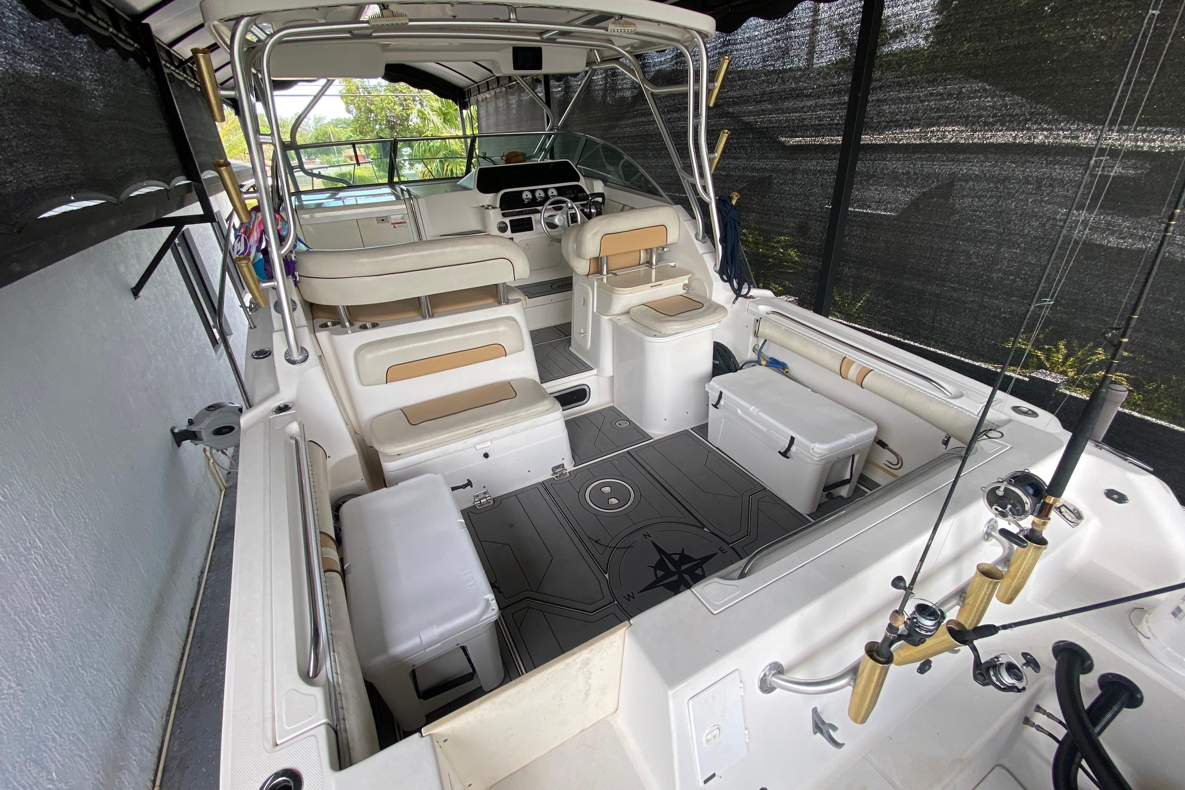 2005 Wellcraft 290 Coastal boat interior with seating, fishing rods, and helm.