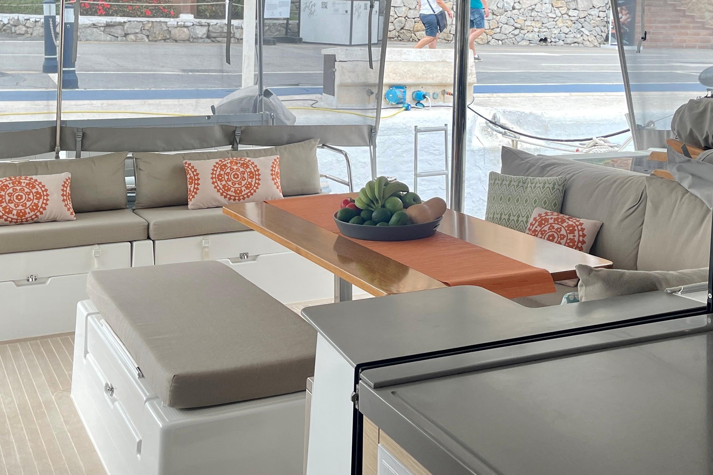 Luxurious 2019 Saona 47 yacht interior with elegant seating and decorative pillows.