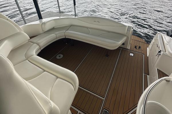 2004 Sea Ray 380 Sundancer boat interior with white seating and wooden deck.