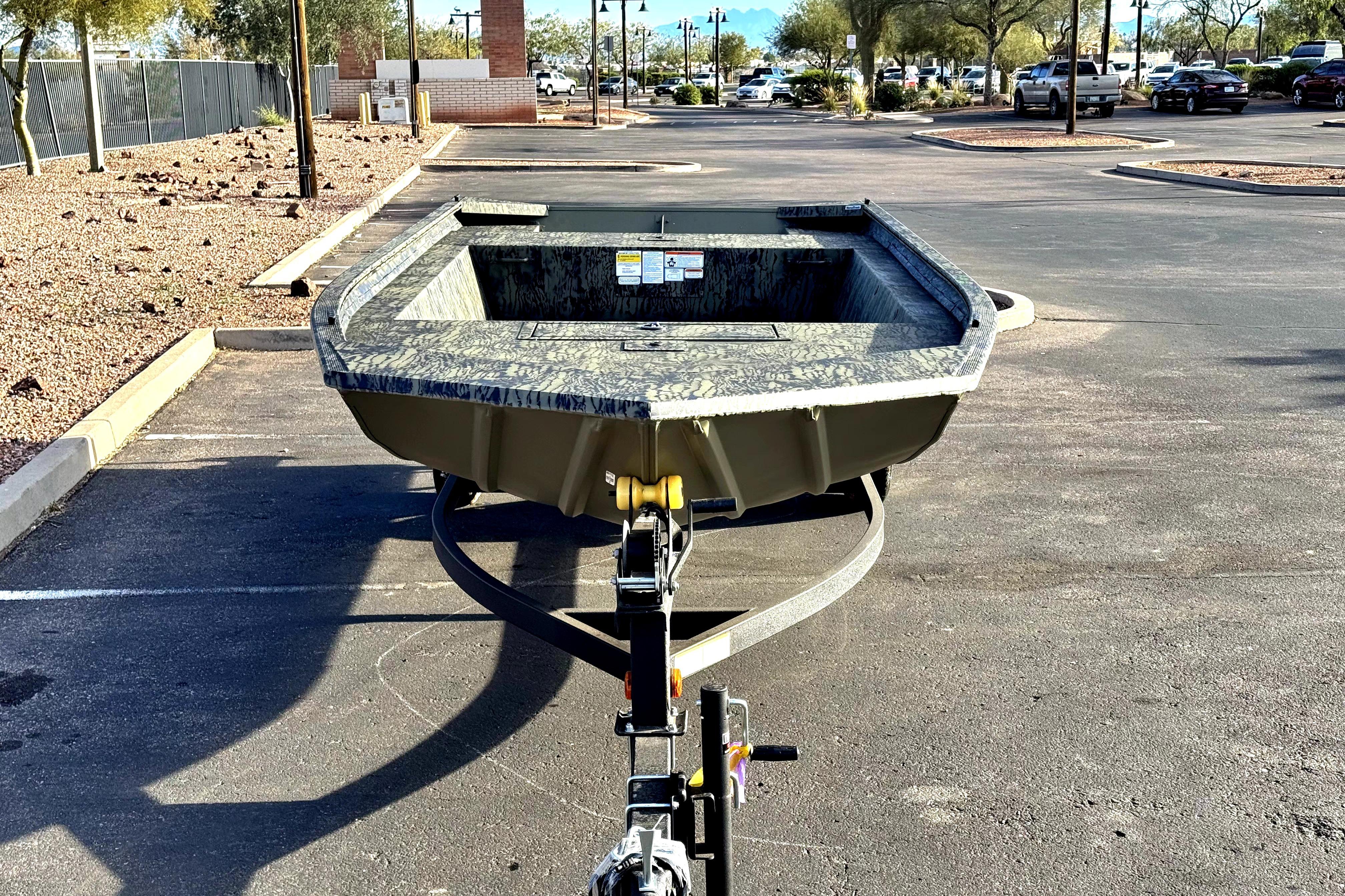 2026 Tracker Grizzly 1754 Utility boat on trailer in parking lot.
