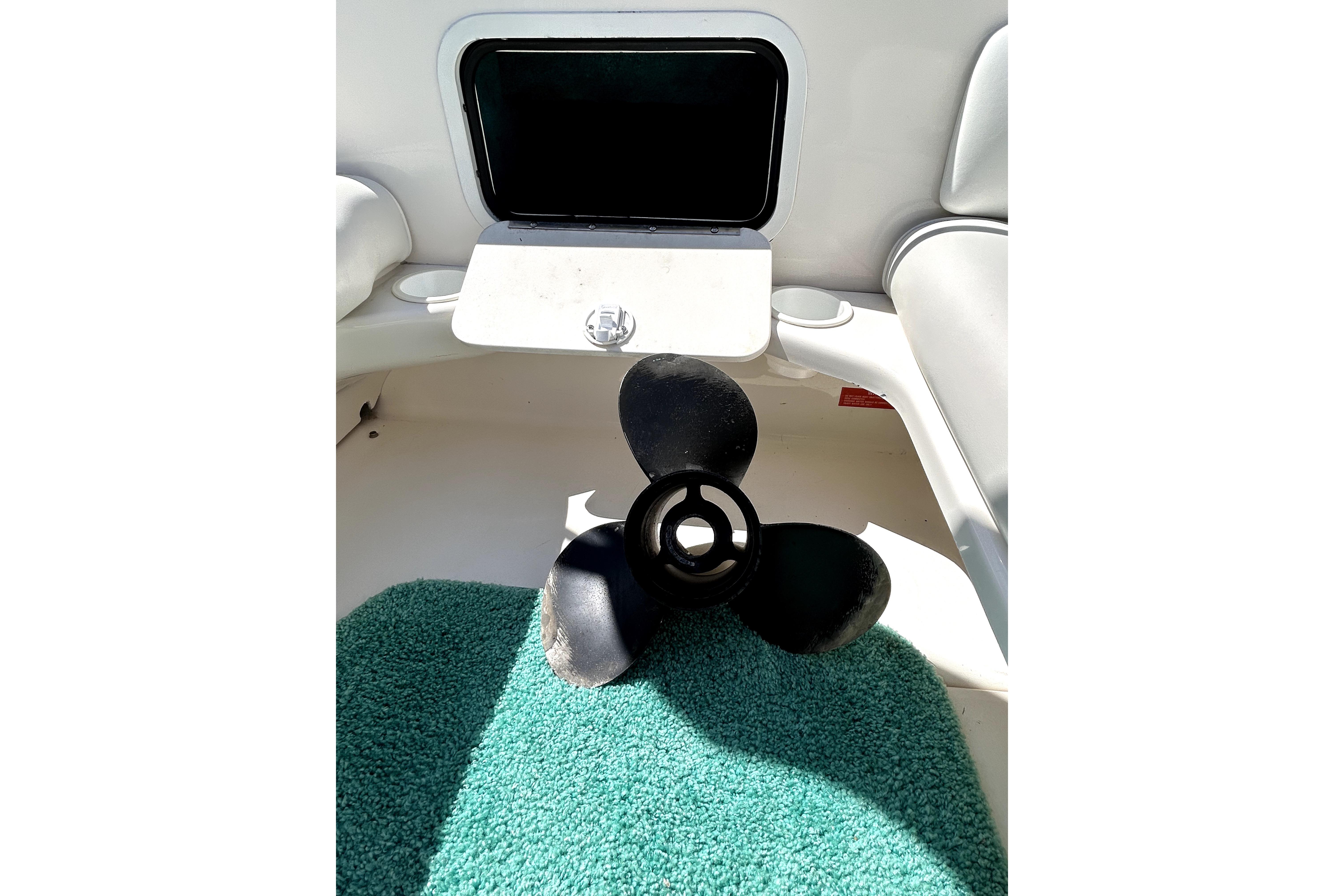 Propeller on green mat inside 1995 Sea Ray 250 Sundancer boat interior.