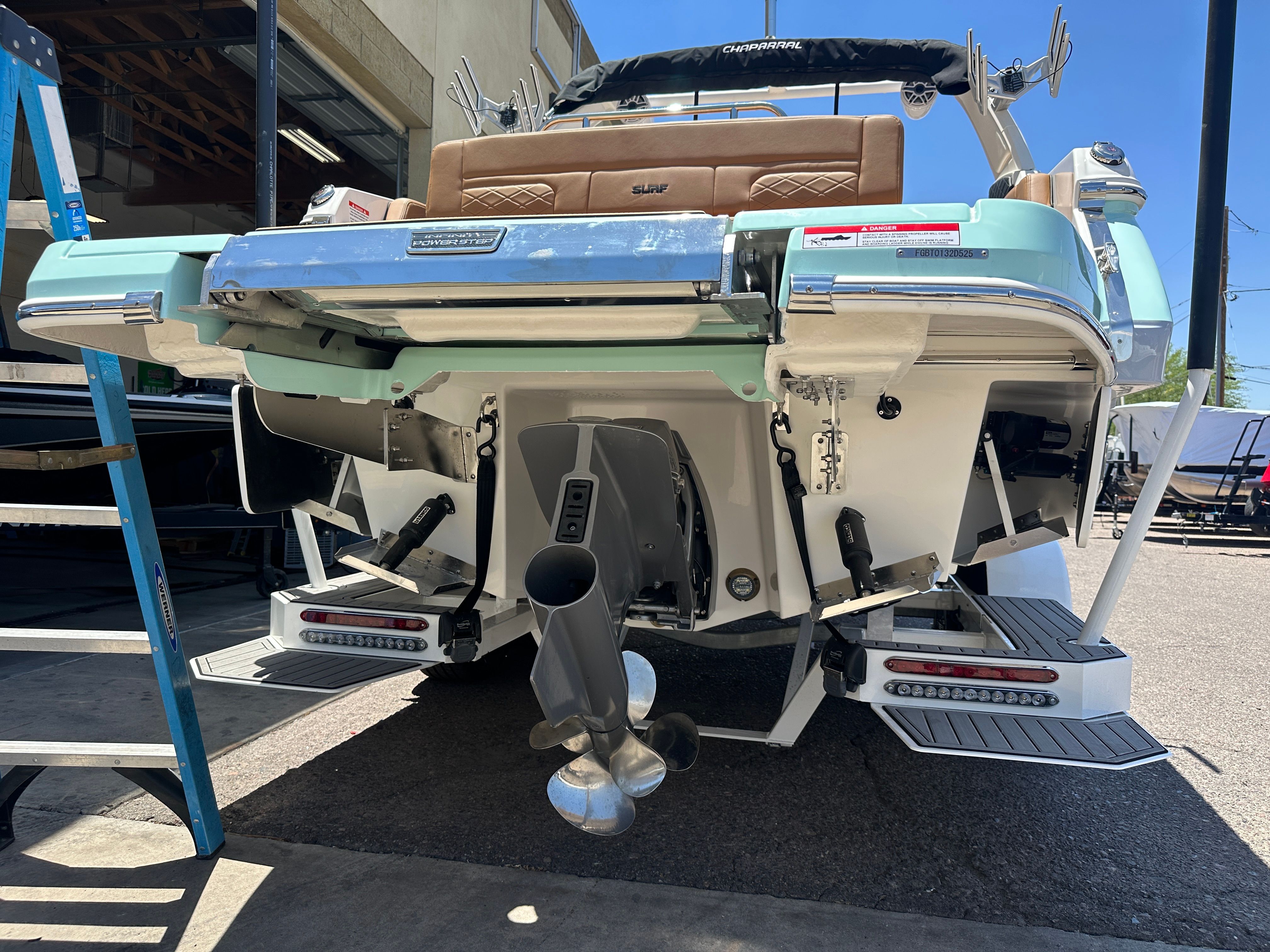 The image shows the rear of a 2025 Chaparral 26 Surf boat with dual engines.