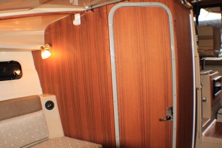 2020 Ranger Tugs R-27 interior with wood paneling and cozy seating area.
