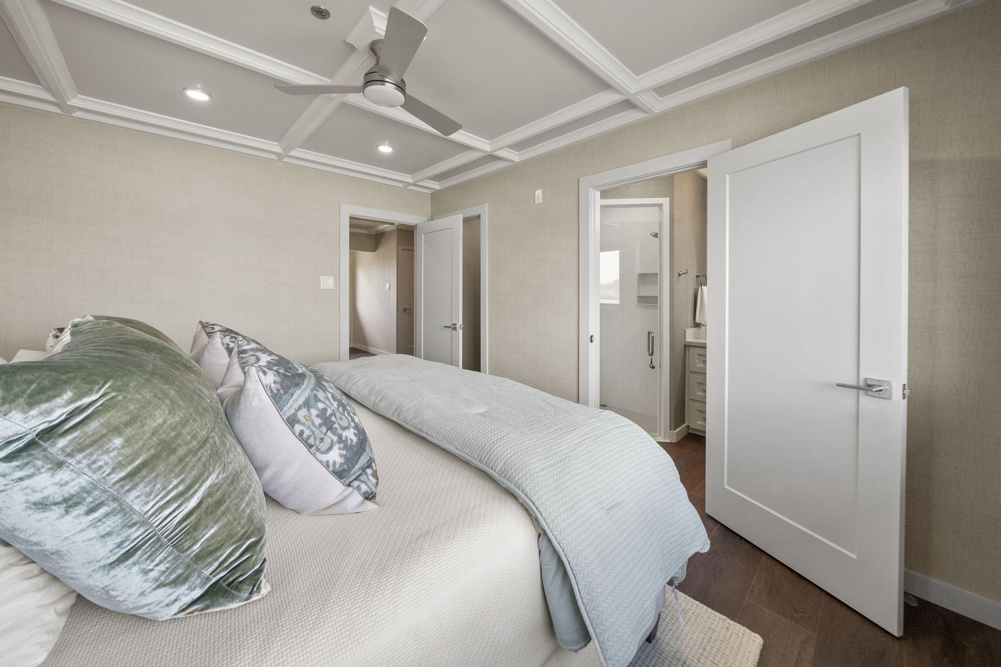 Luxurious bedroom interior with plush pillows, modern ceiling fan, and en-suite bathroom, Breaux Brothers 120 GLV.