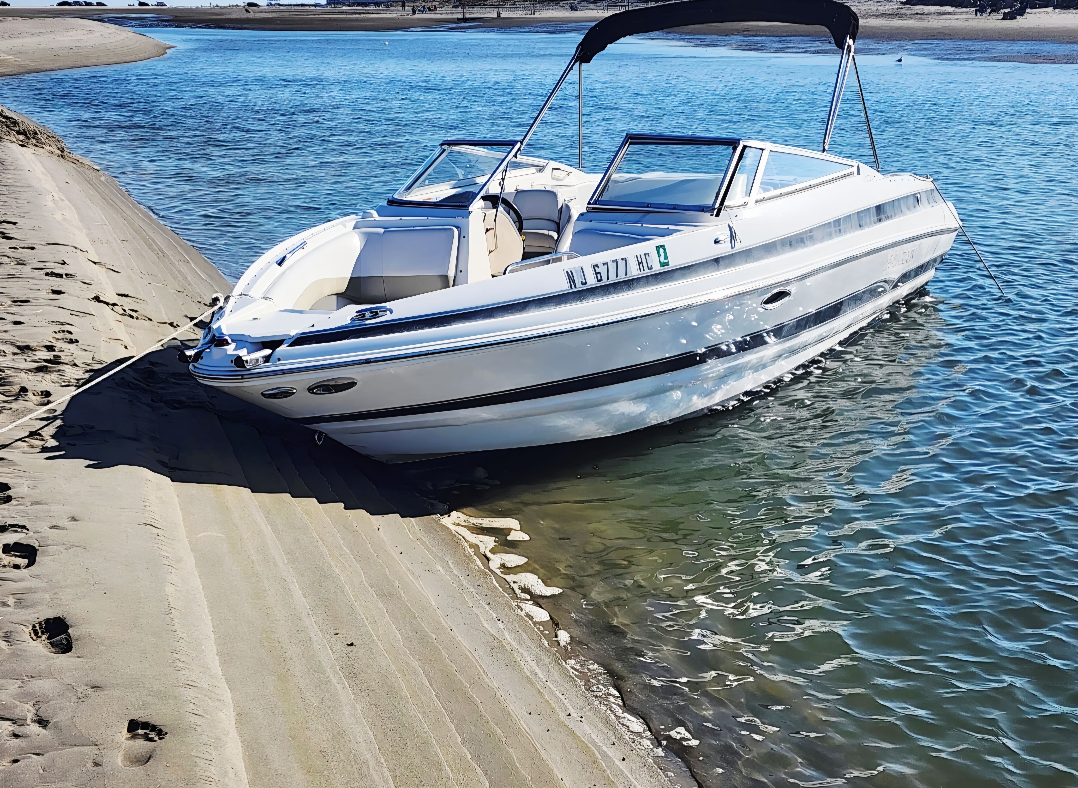 2007 Larsen LXi 268 boat parked on sandy shore.