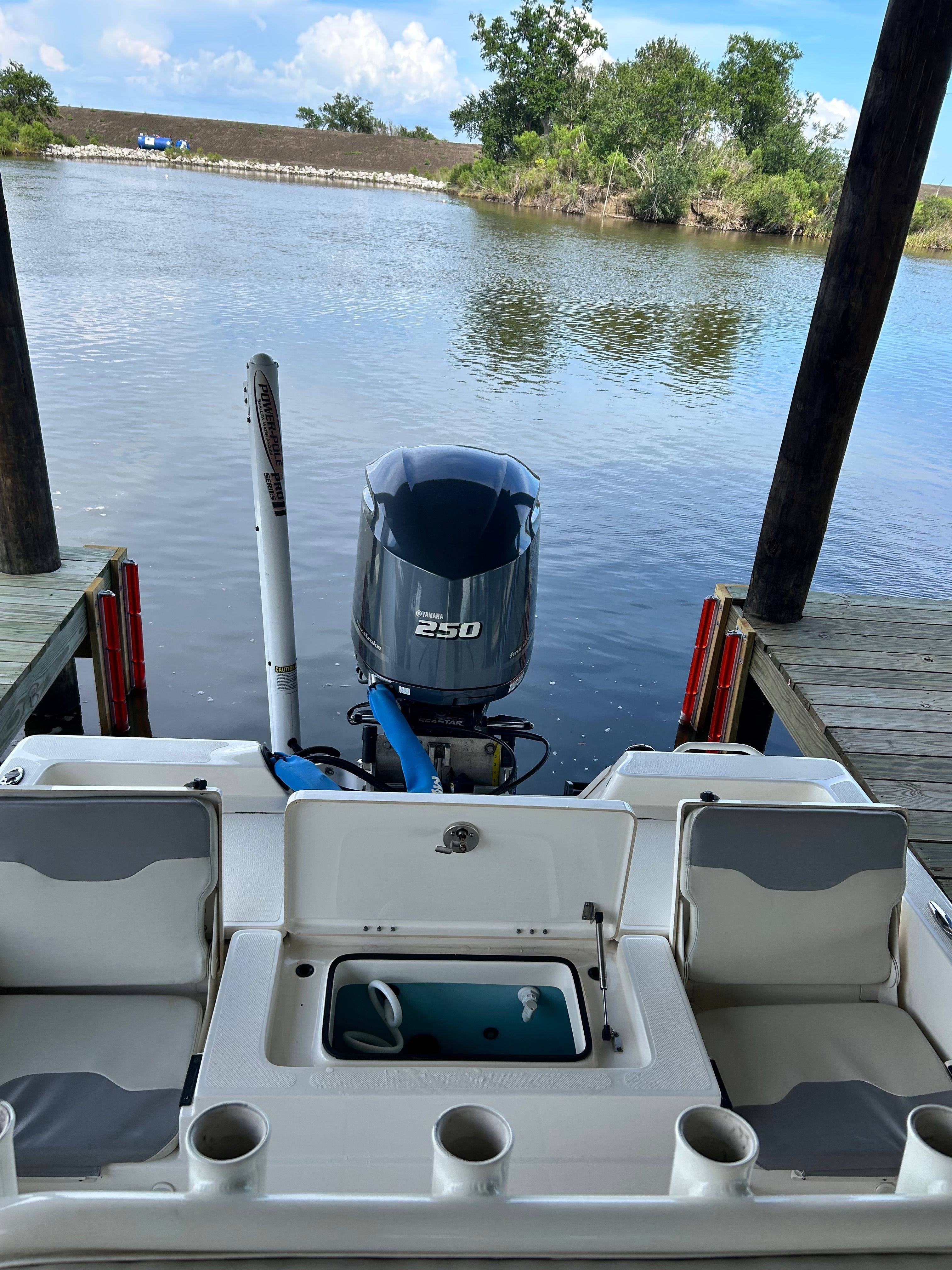 The image shows the stern of a 2016 Skeeter SX230 boat with a 250 HP outboard motor, docked by calm water.