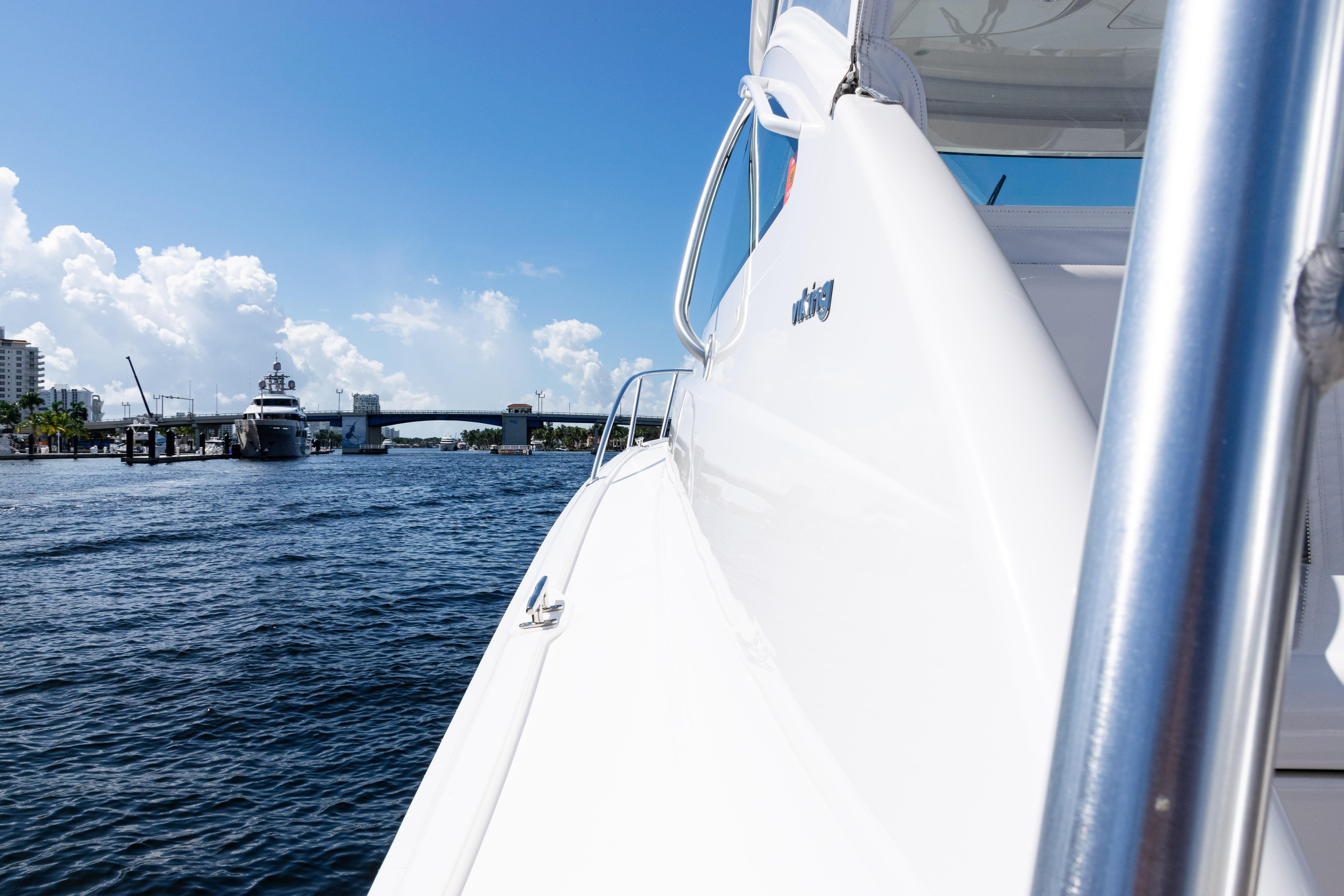 2021 Viking 44 Open yacht cruising near a bridge on a sunny day.