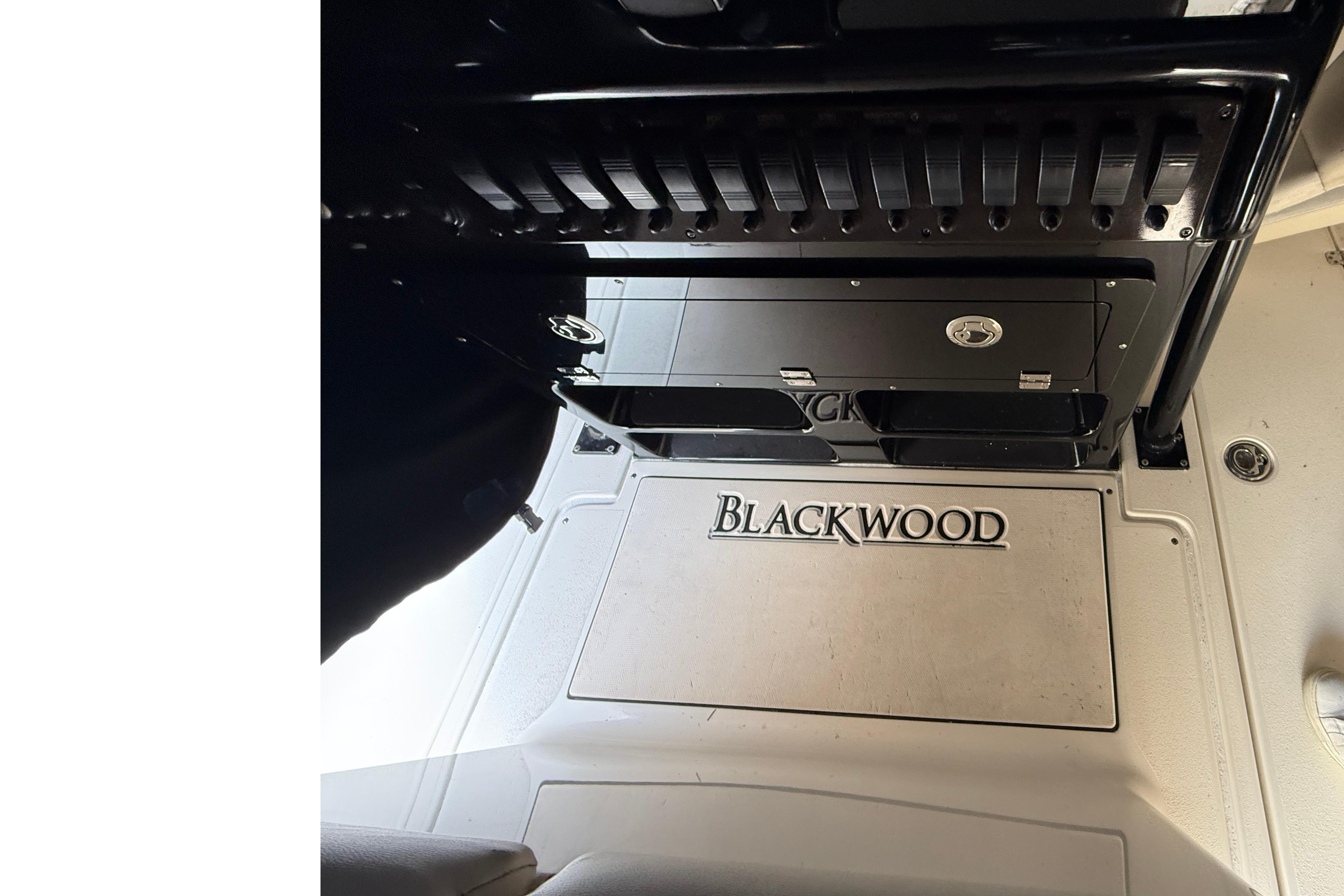 2015 Blackwood 27 boat interior with branded flooring and storage compartments.