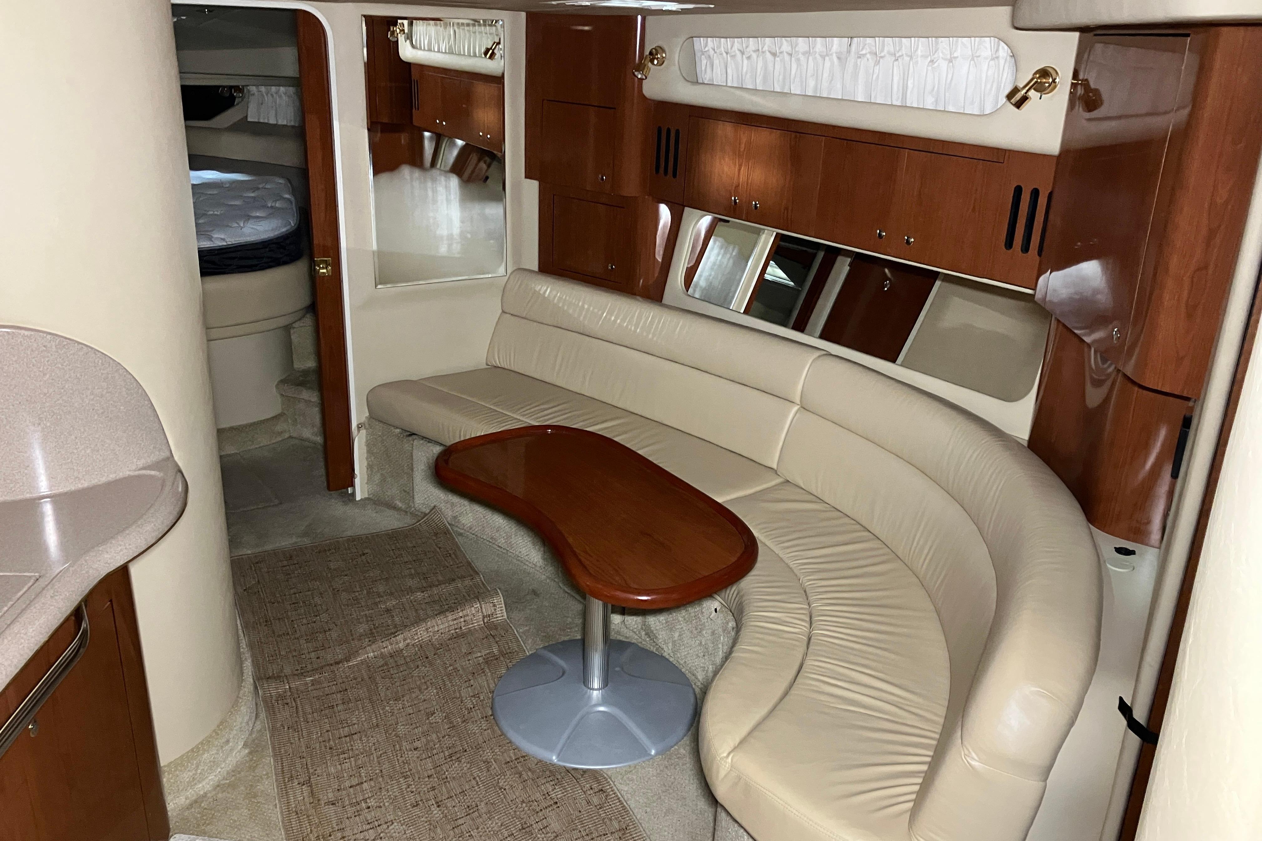 Luxurious interior of a 2002 Sea Ray 410 Sundancer yacht with leather seating and wood accents.