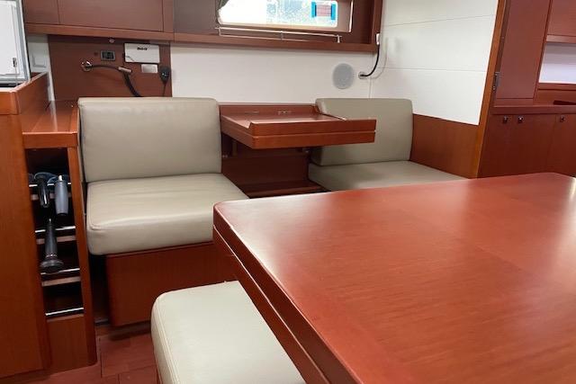 Interior of 2018 Beneteau Oceanis 45 yacht with wooden dining area and beige seating.