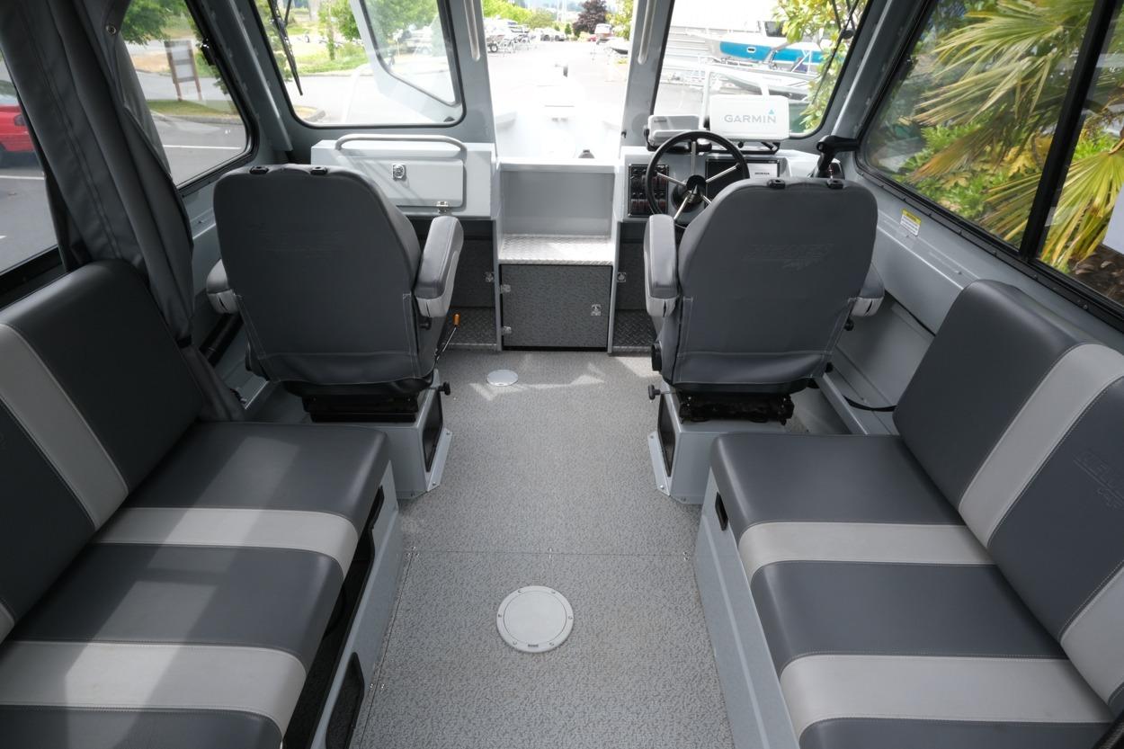 Interior of a 2021 Hewescraft 240 Ocean Pro ET Hardtop with gray seating and steering wheel.