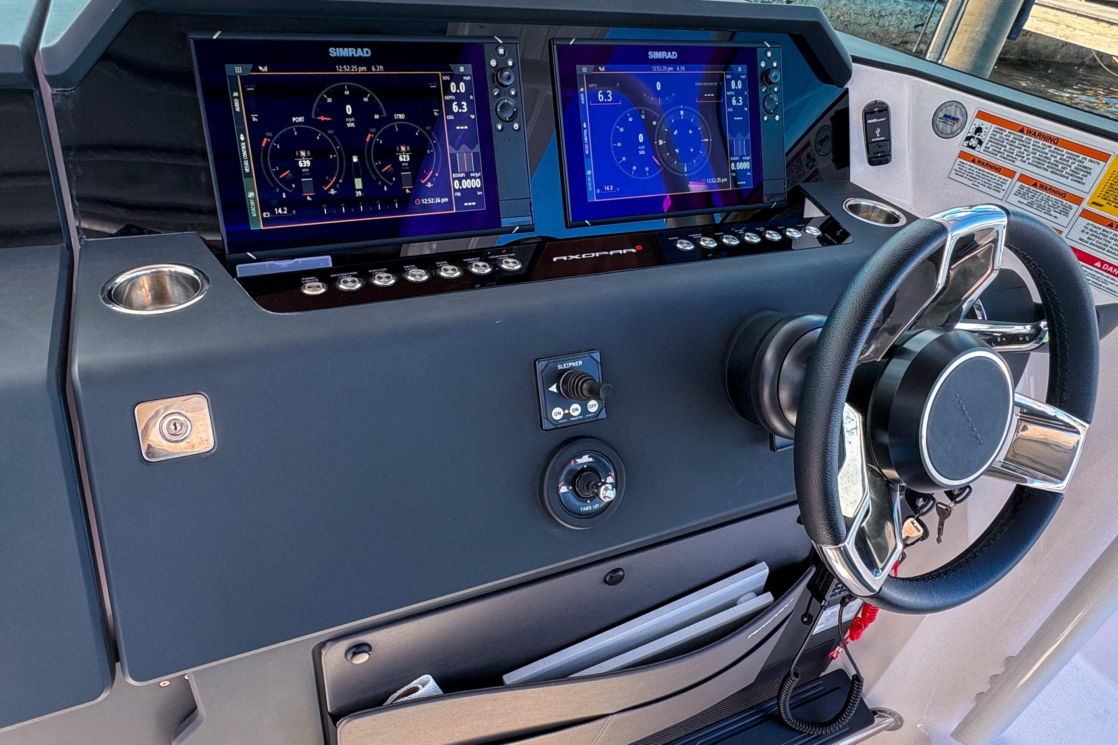 2024 Axopar 37 Sun Top dashboard with dual Simrad displays and steering wheel.