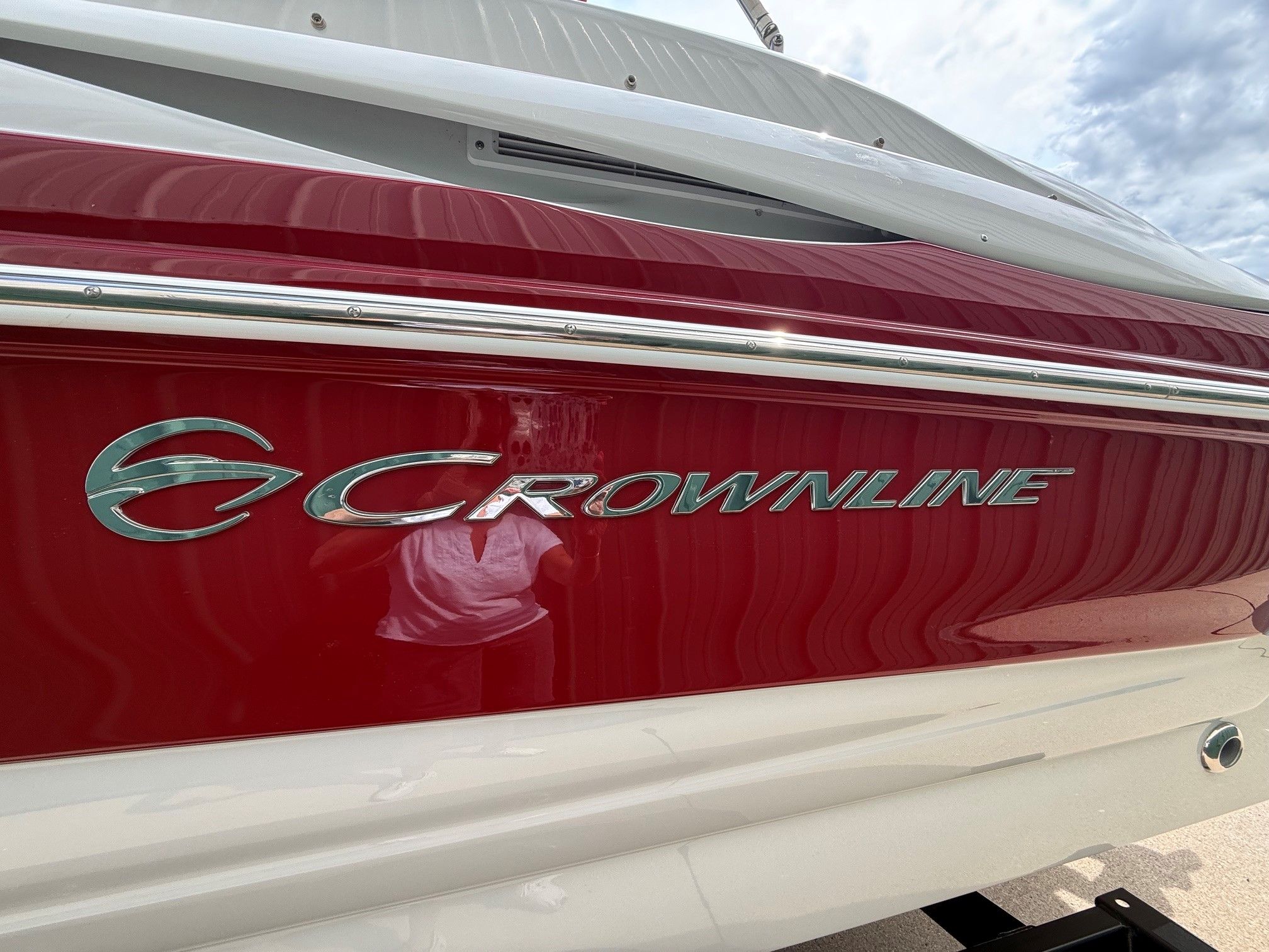 Close-up of the red Crownline 252 EX boat hull with silver logo.