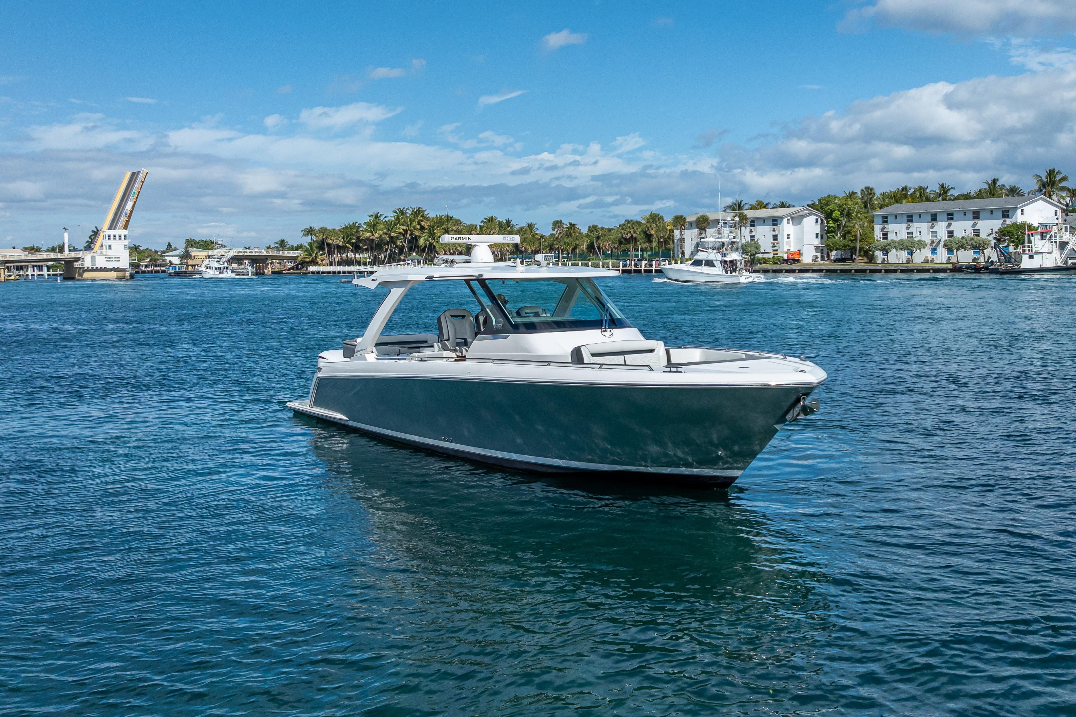 2019 Tiara Sport 38 LS boat cruising on a sunny day near a drawbridge.