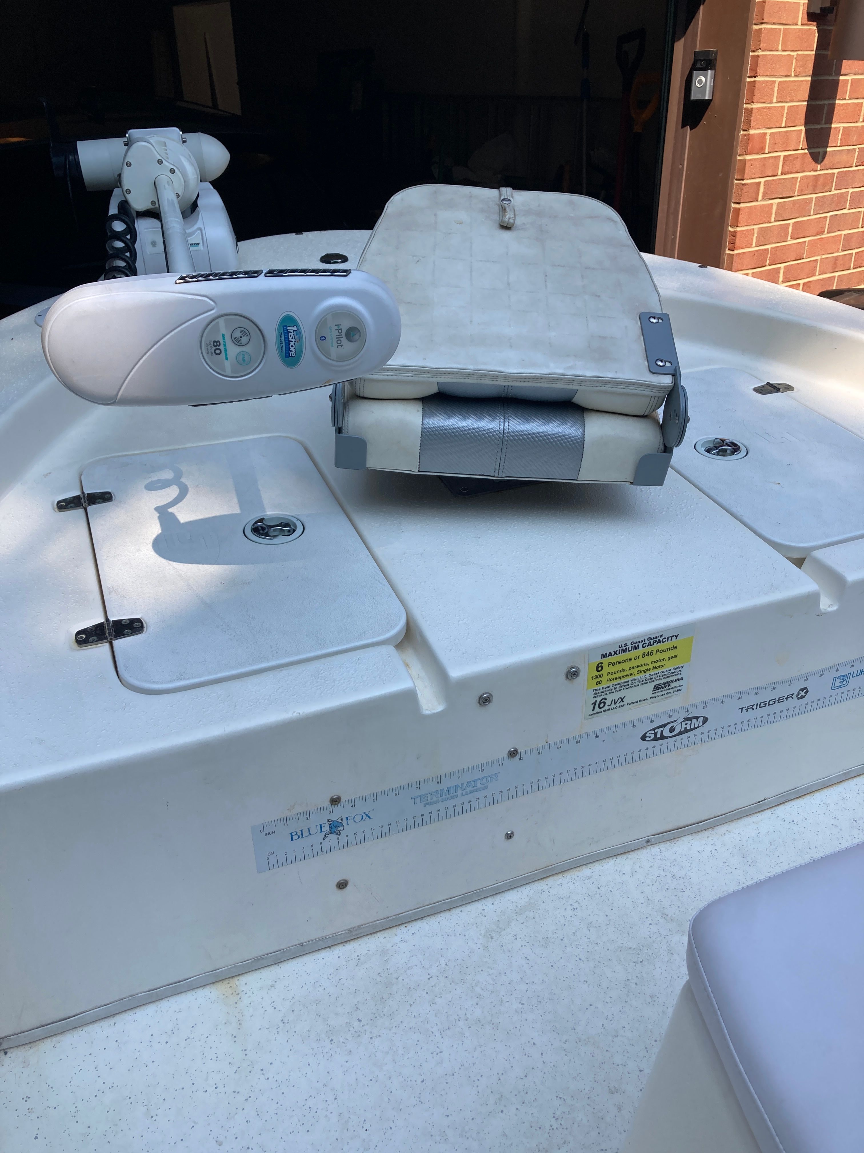 A 2012 Carolina Skiff JVX16CC with a steering console and bench seat on the deck.