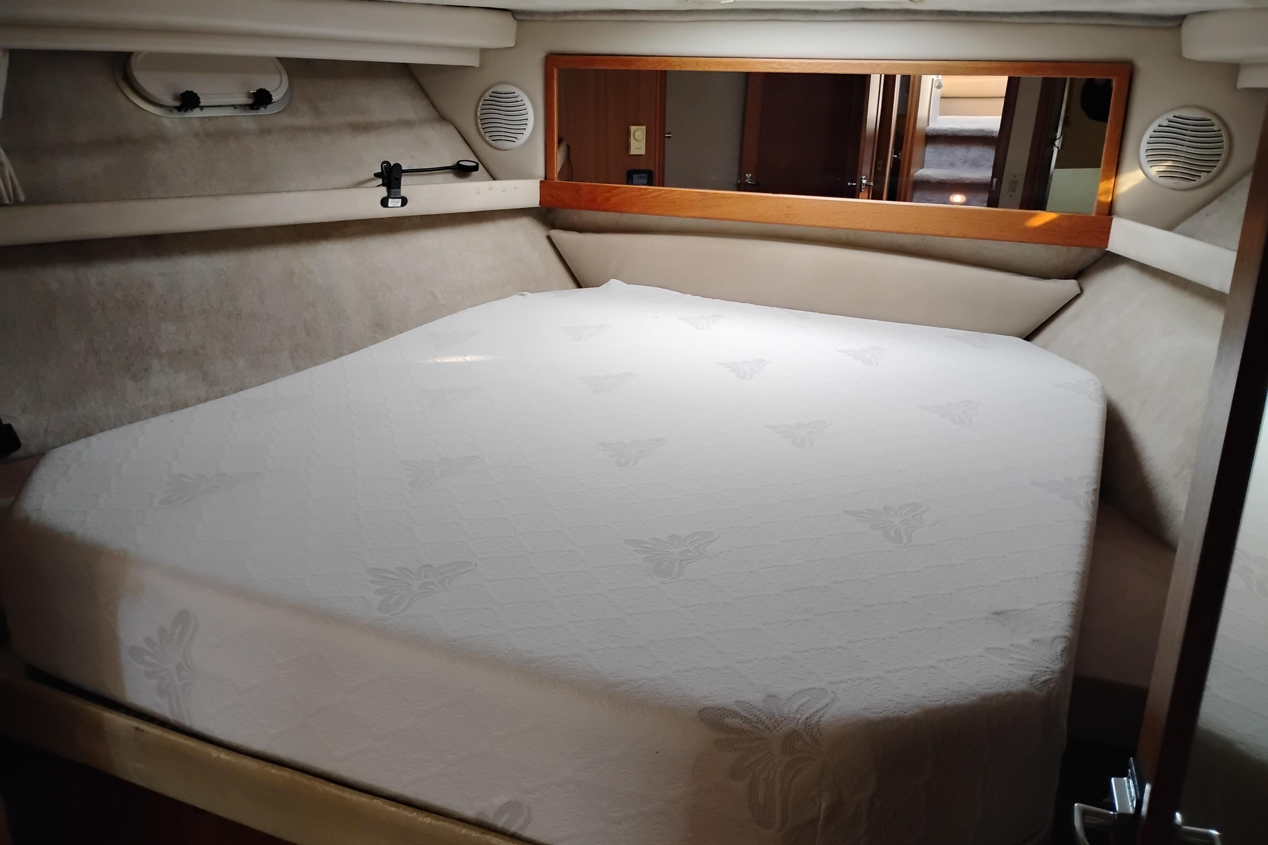 Cozy bedroom in 2000 Bayliner 3988 Command Bridge Motoryacht with plush bedding.