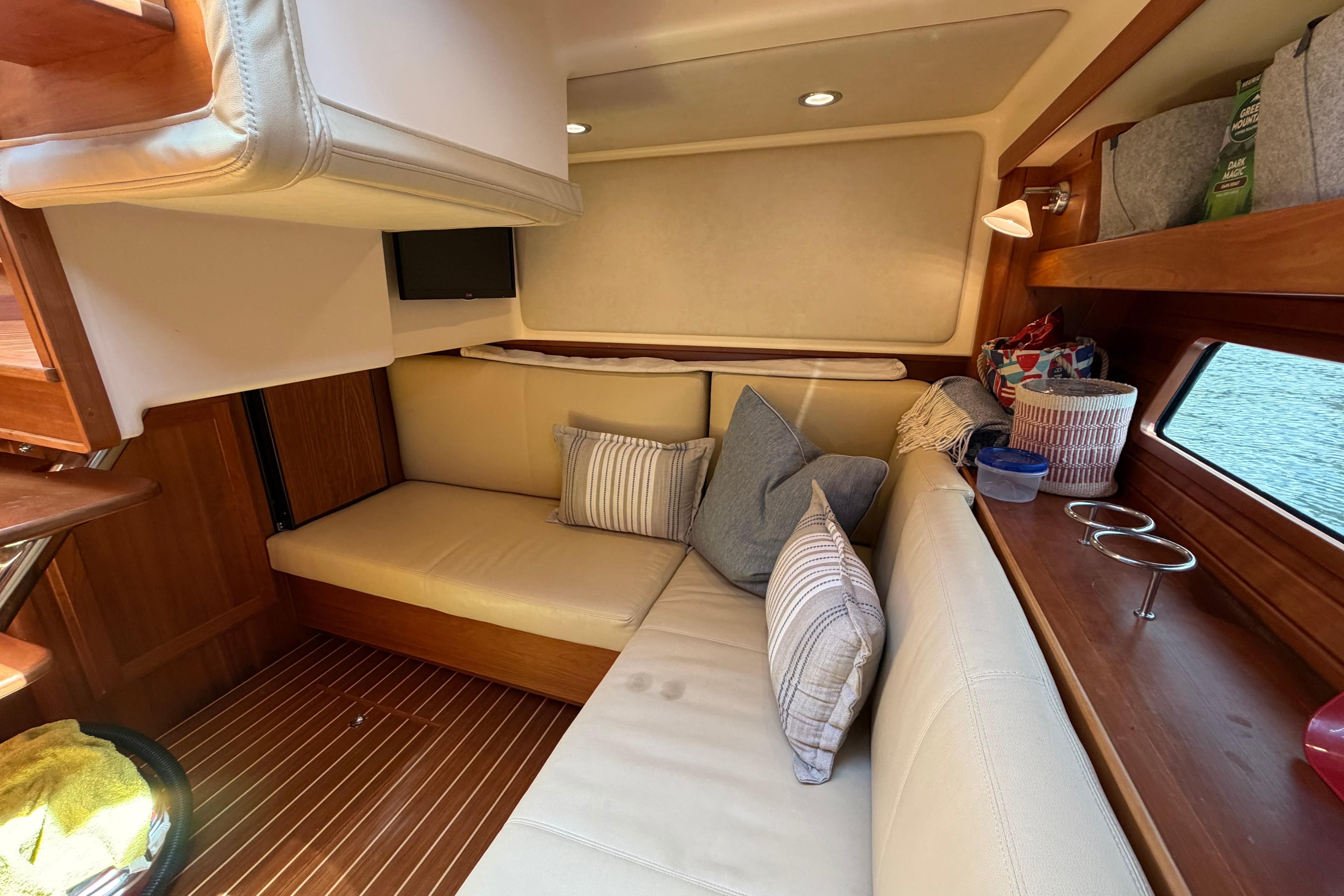 2015 Sabre 38 Salon Express interior with cozy seating, cushions, and wooden accents.