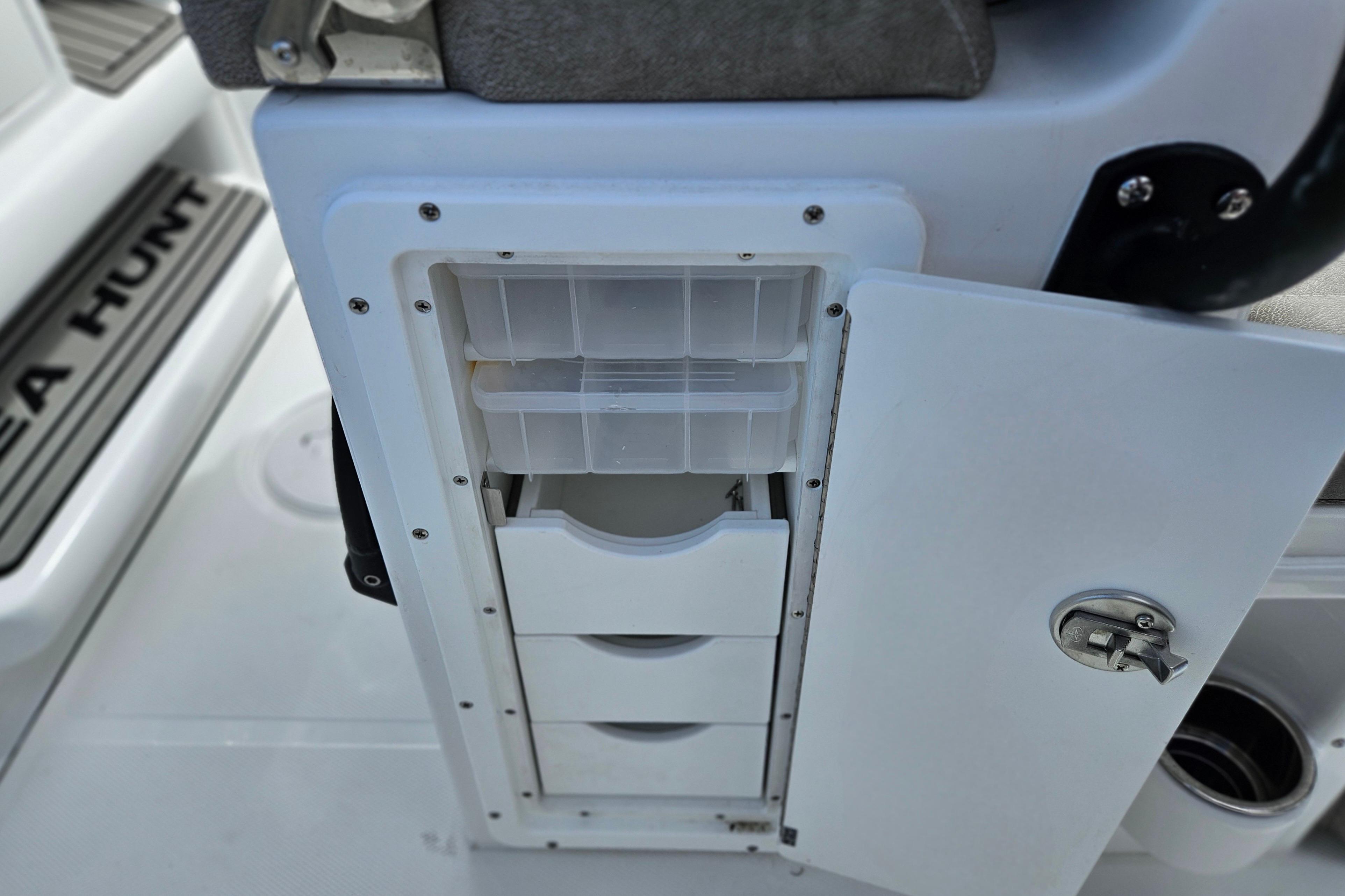 Storage compartment on 2026 Sea Hunt Ultra 245 SE boat with open drawers.