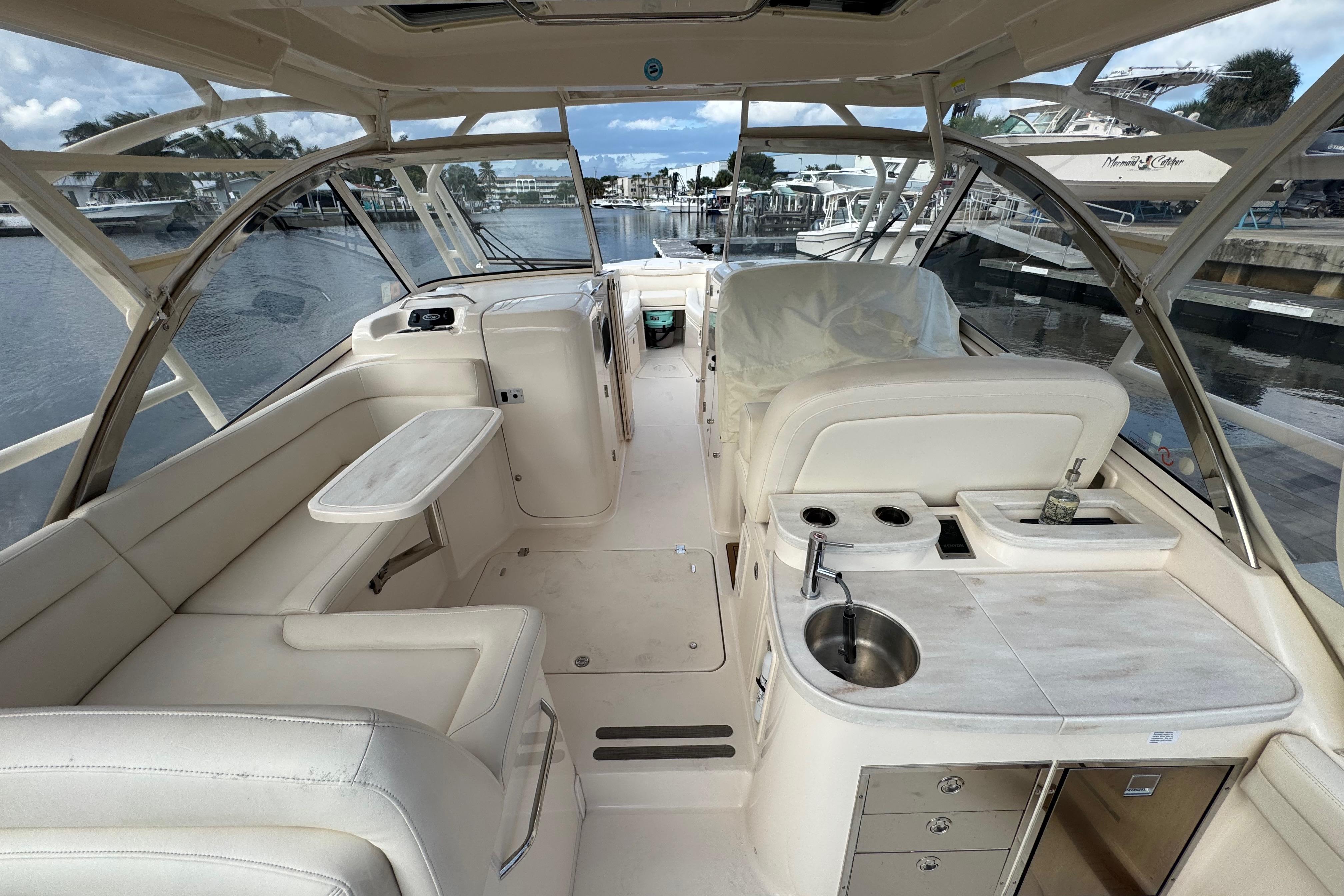 2024 Grady-White Freedom 335 boat interior with seating, sink, and marina view.