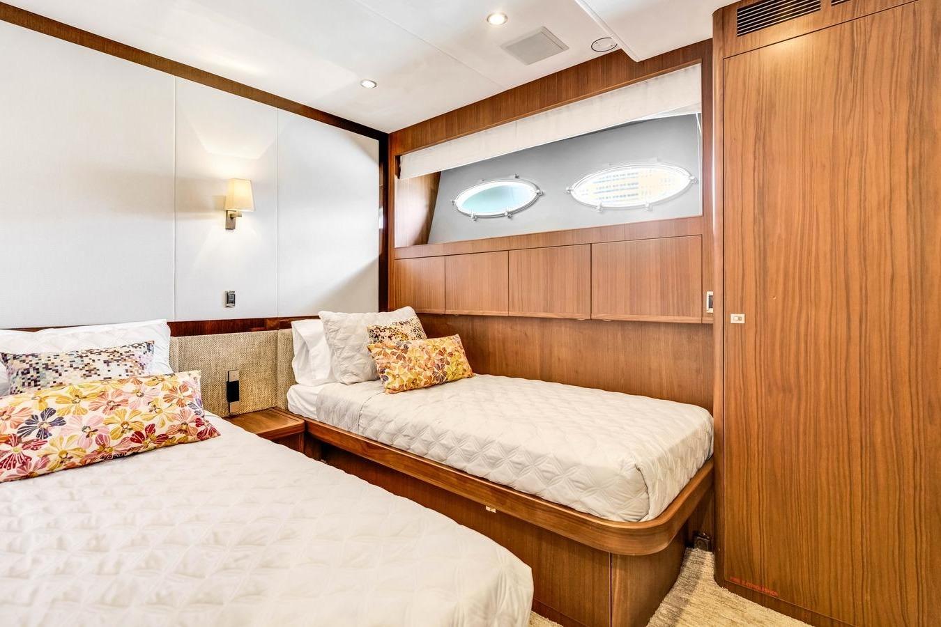 Luxurious cabin interior of 2012 Princess 85 yacht with twin beds and elegant wood paneling.
