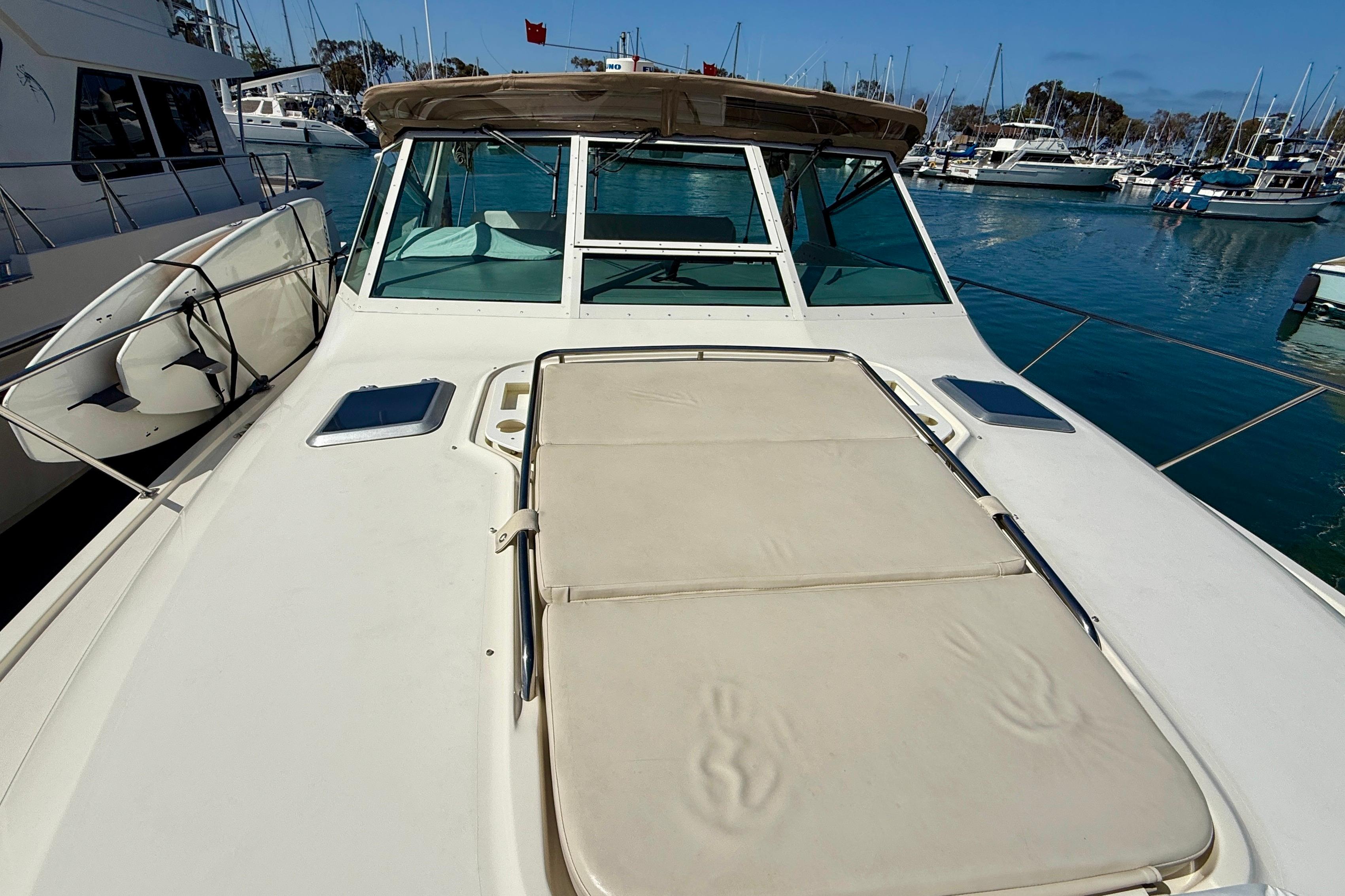 1998 Tiara Yachts 3500 Express on water, featuring spacious deck and marina backdrop.
