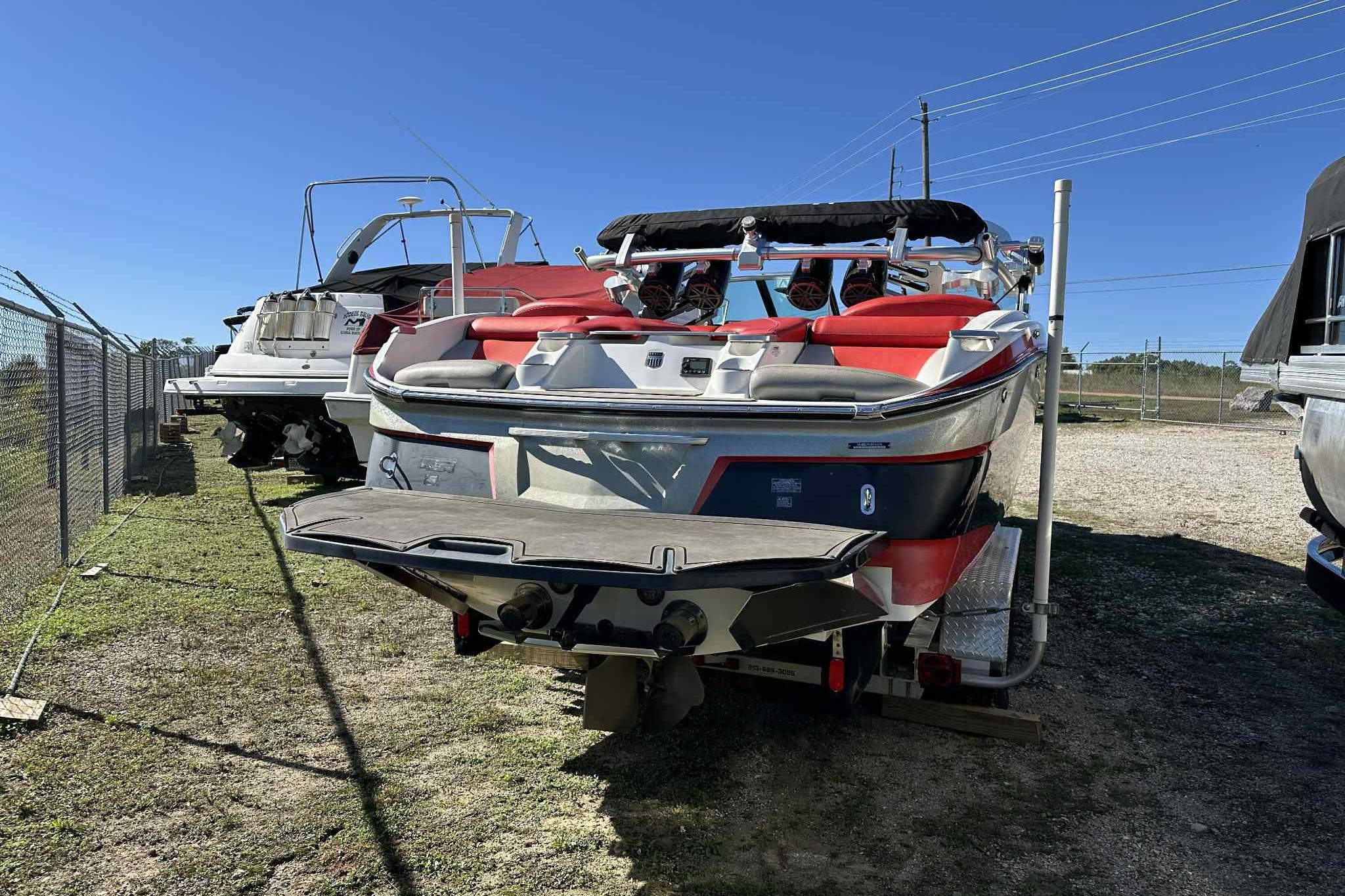 2016 MasterCraft X23 boat in storage, rear view with red and white design.