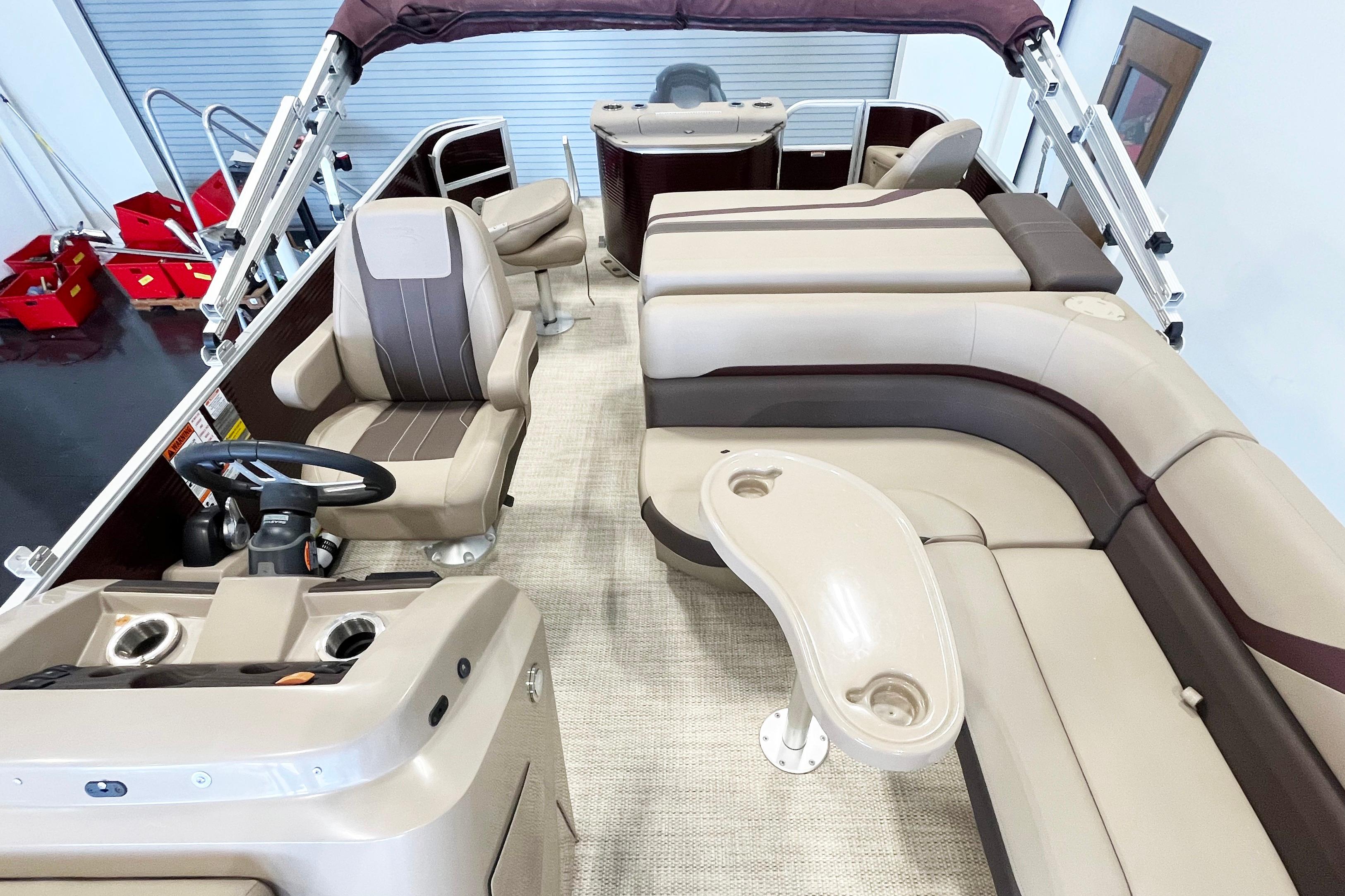 Interior of a 2020 Bennington SX25 pontoon boat with beige seating and steering console.