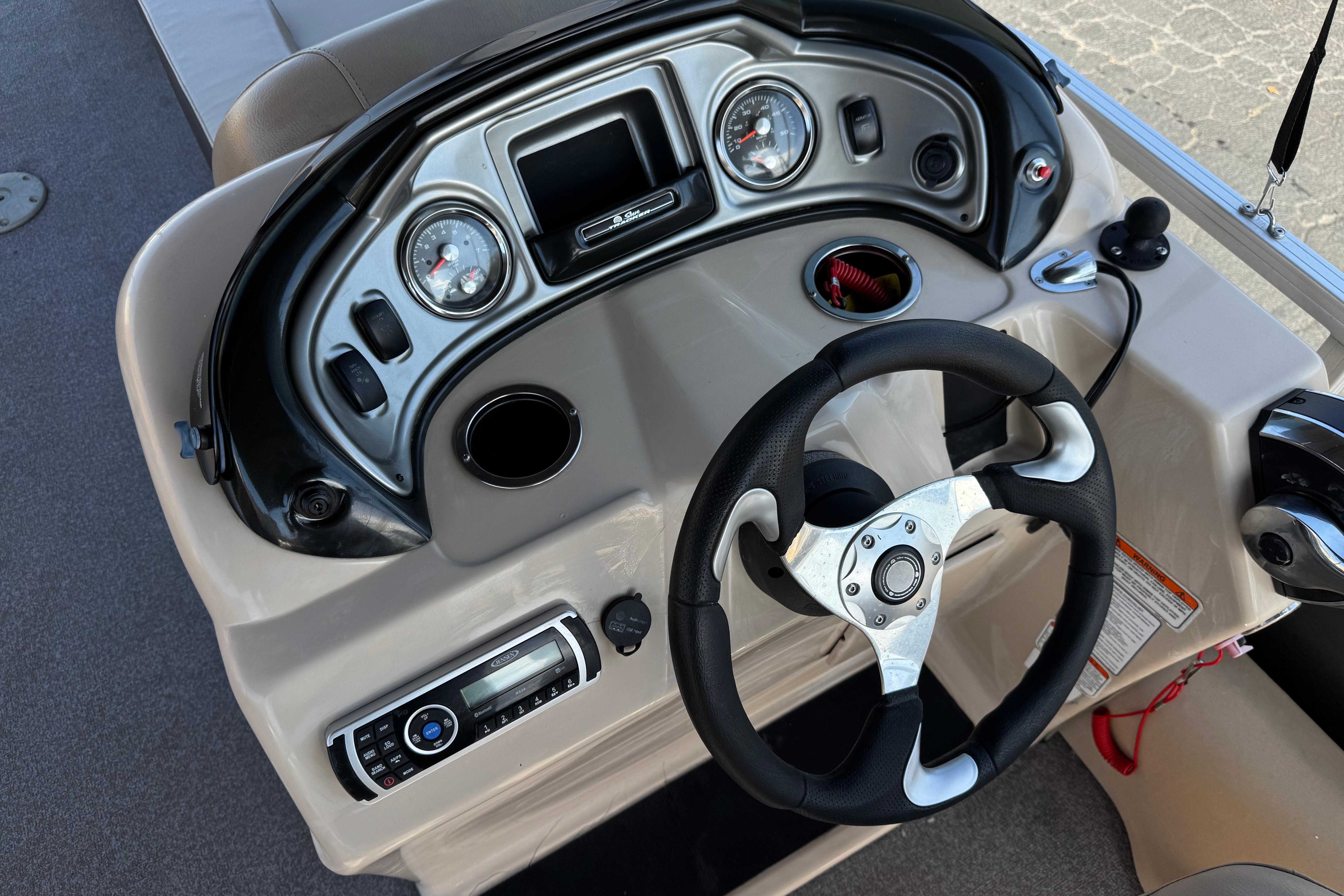 2018 Sun Tracker SportFish 22 DLX boat dashboard with steering wheel and control panel.