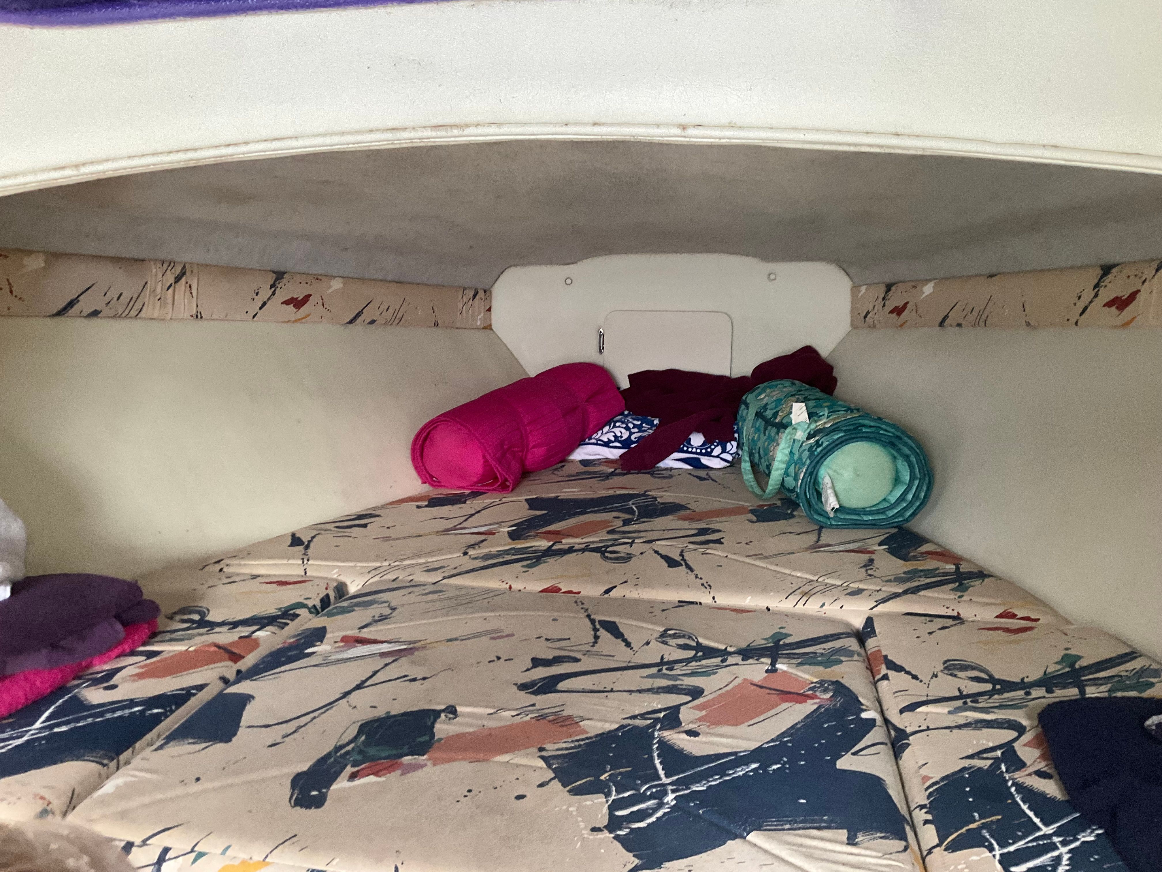 Interior of a 1995 Baja Caliber with patterned cushions and rolled-up blankets.