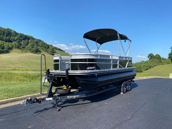 2024 Ranger Reata 223C pontoon boat on trailer, parked on a scenic road.