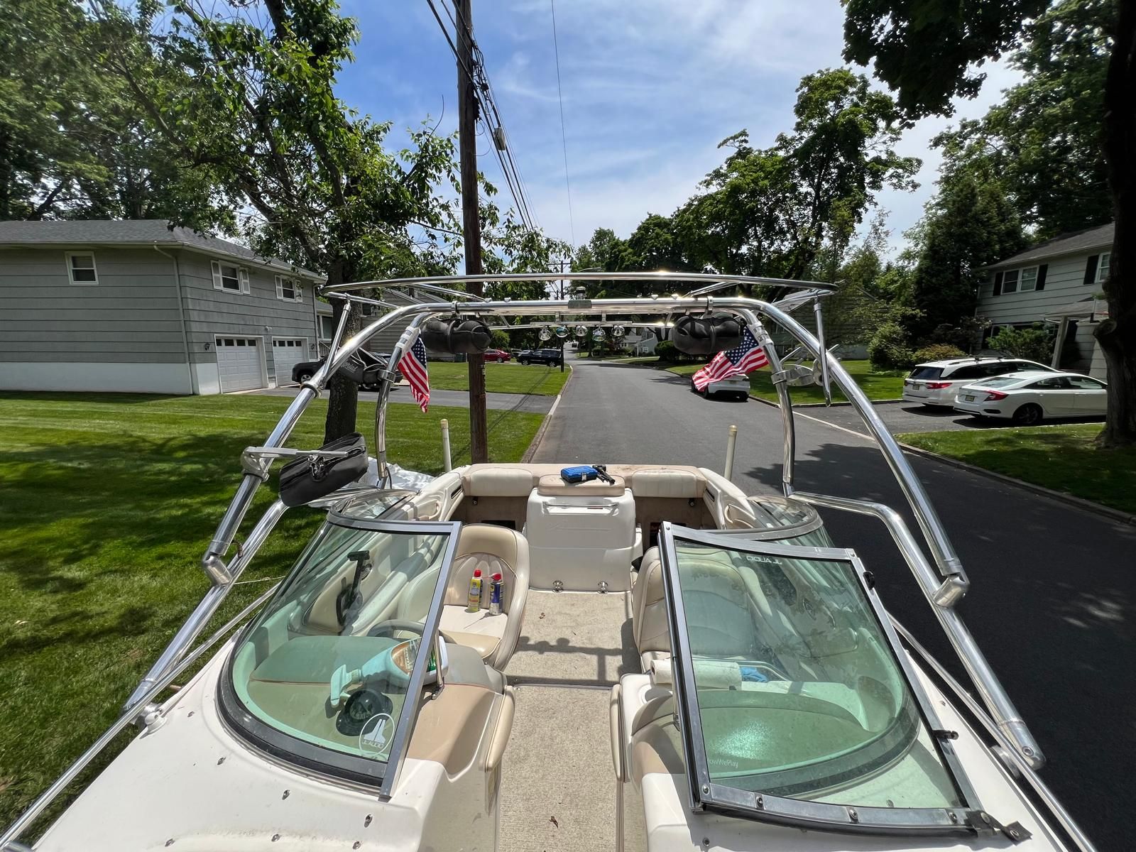 A 1997 Sea Ray 190 Bow Rider is parked on a street. It features two seats and a windshield.
